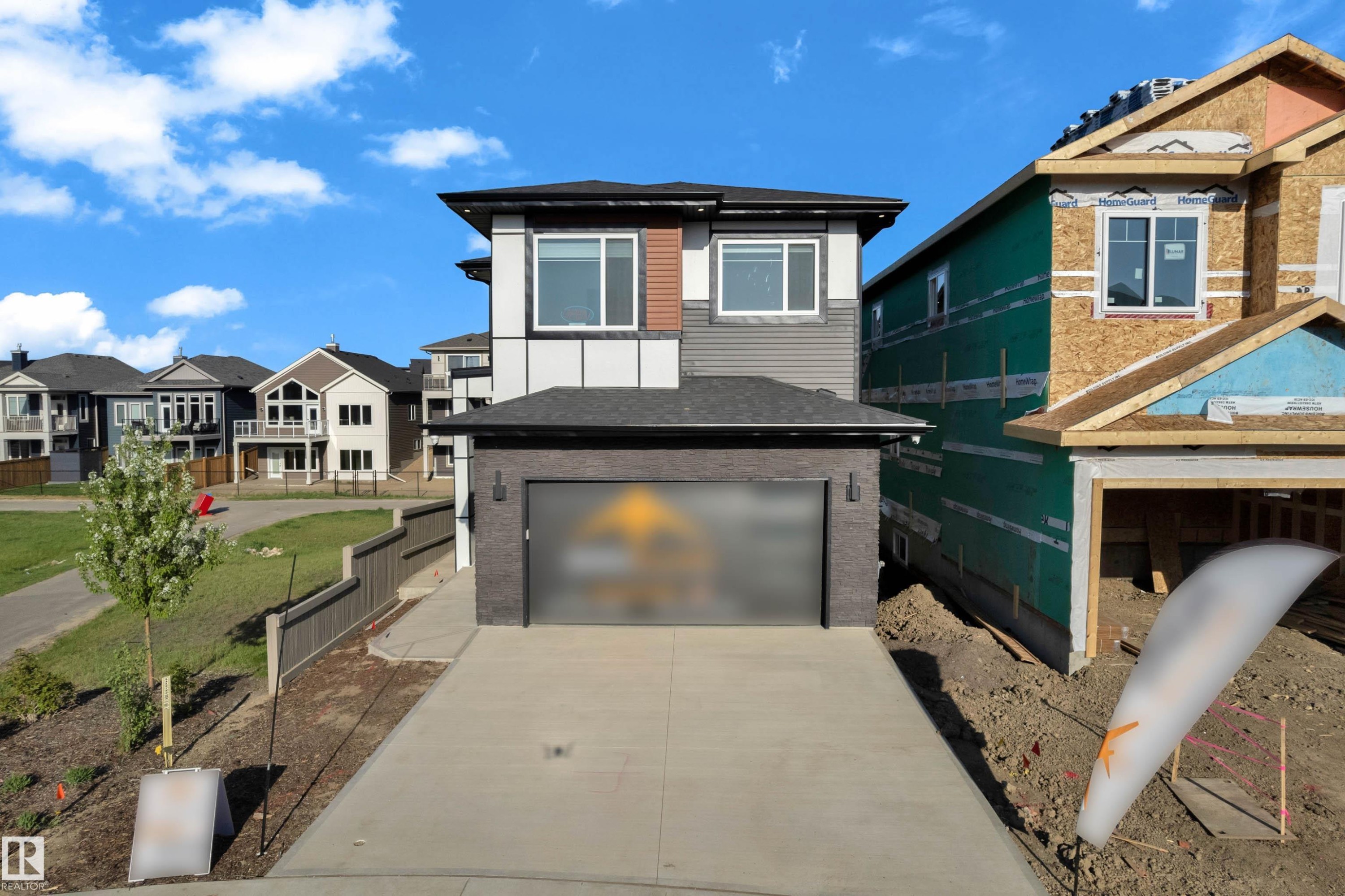 Contemporary two-story residence featuring a striking multi-textured facade with dark brick, gray siding, and white and brown accent panels - 206 Linden Loop, Leduc, AB