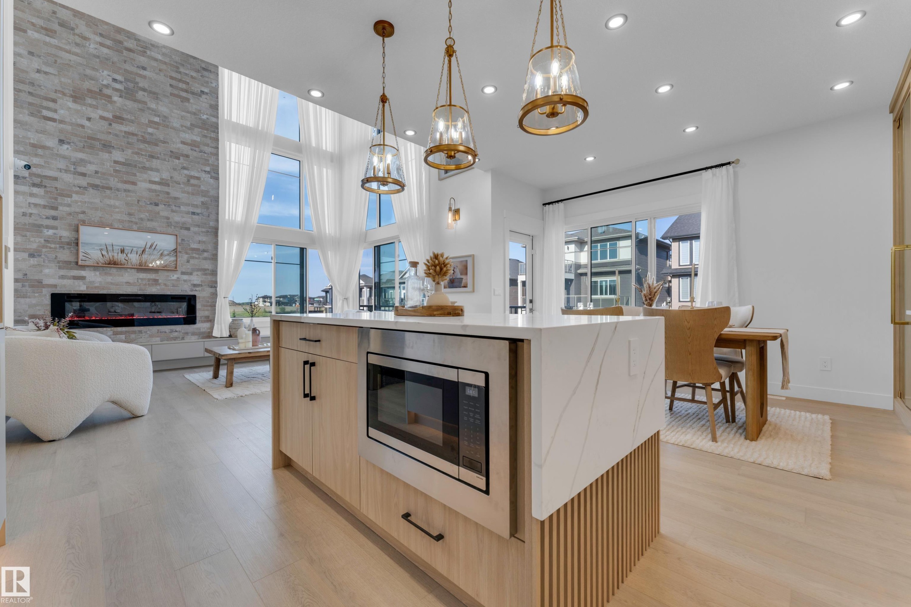 Kitchen island featuring a waterfall countertop with integrated microwave - 206 Linden Loop, Leduc, AB