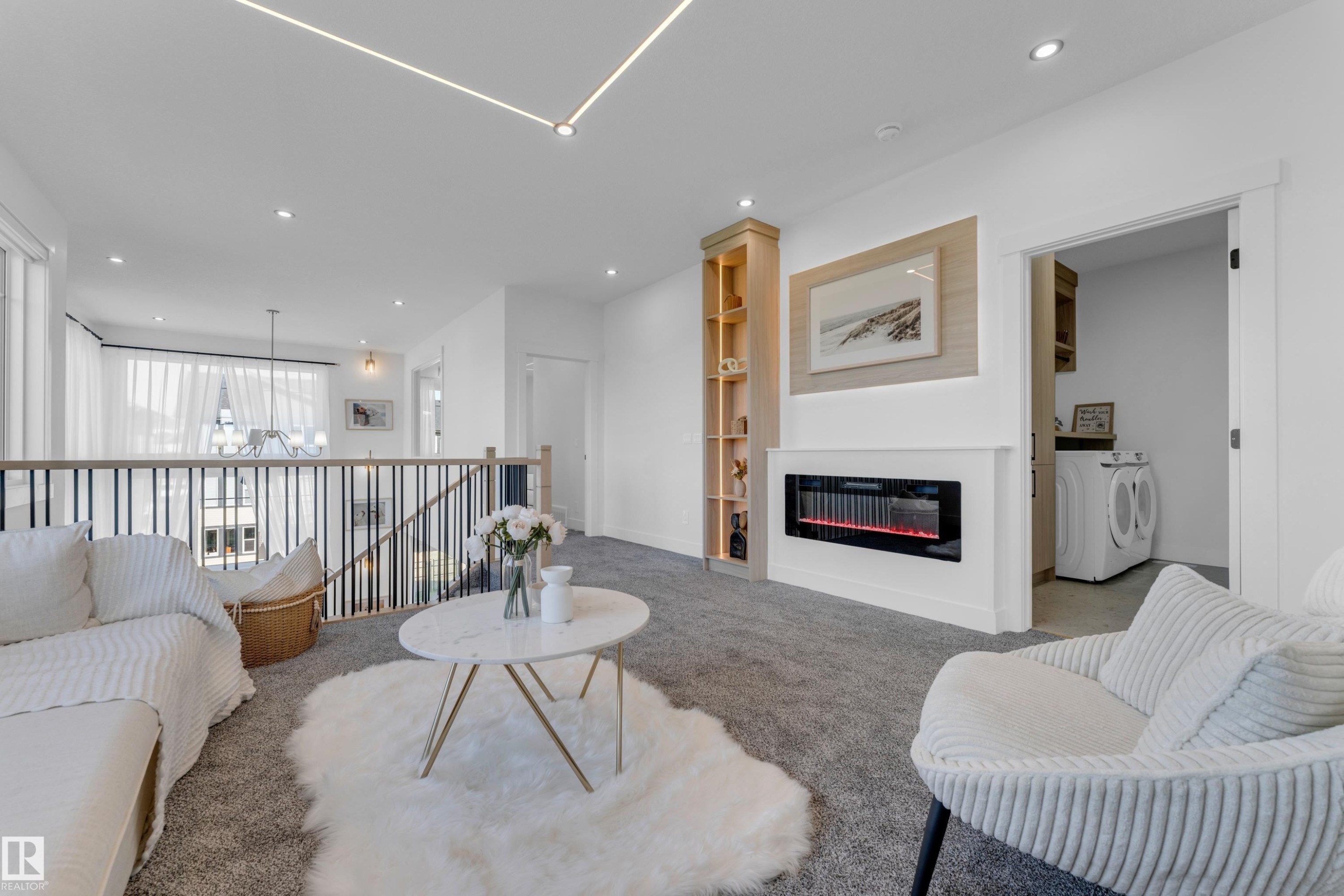Loft area featuring grey carpeting, recessed lighting, and a linear electric fireplace with integrated shelving - 206 Linden Loop, Leduc, AB