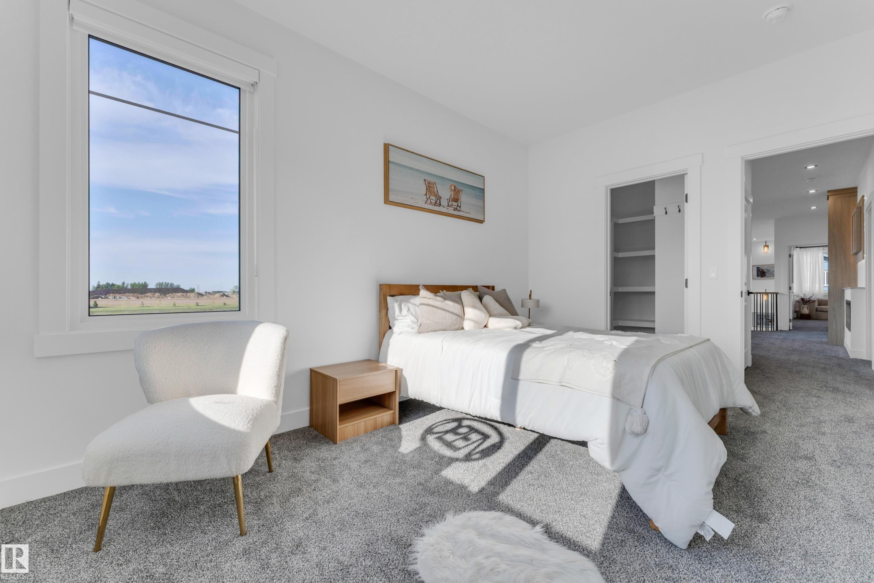 Large window with white trim, gray carpeted flooring, built-in closet shelving, bright white walls, and a recessed doorway - 206 Linden Loop, Leduc, AB