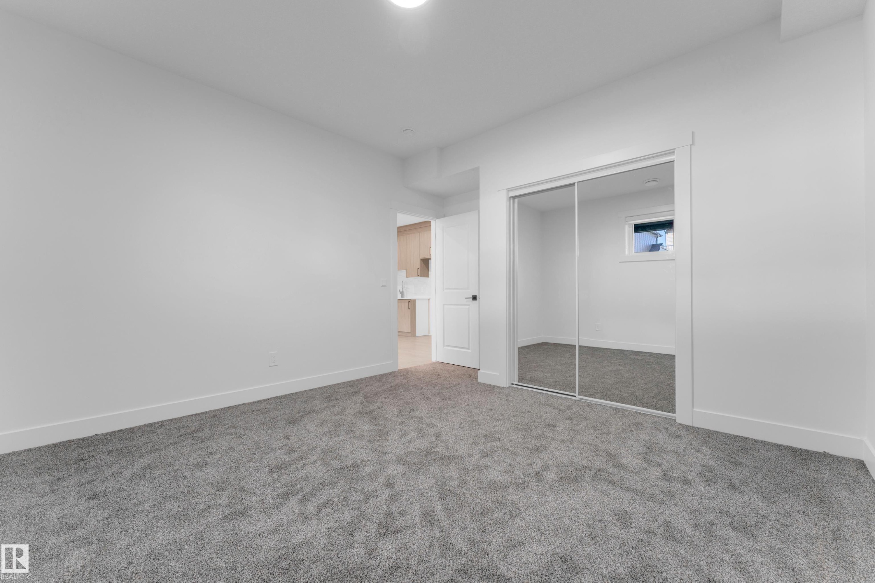 Spacious room featuring gray carpet flooring and white painted walls - 206 Linden Loop, Leduc, AB