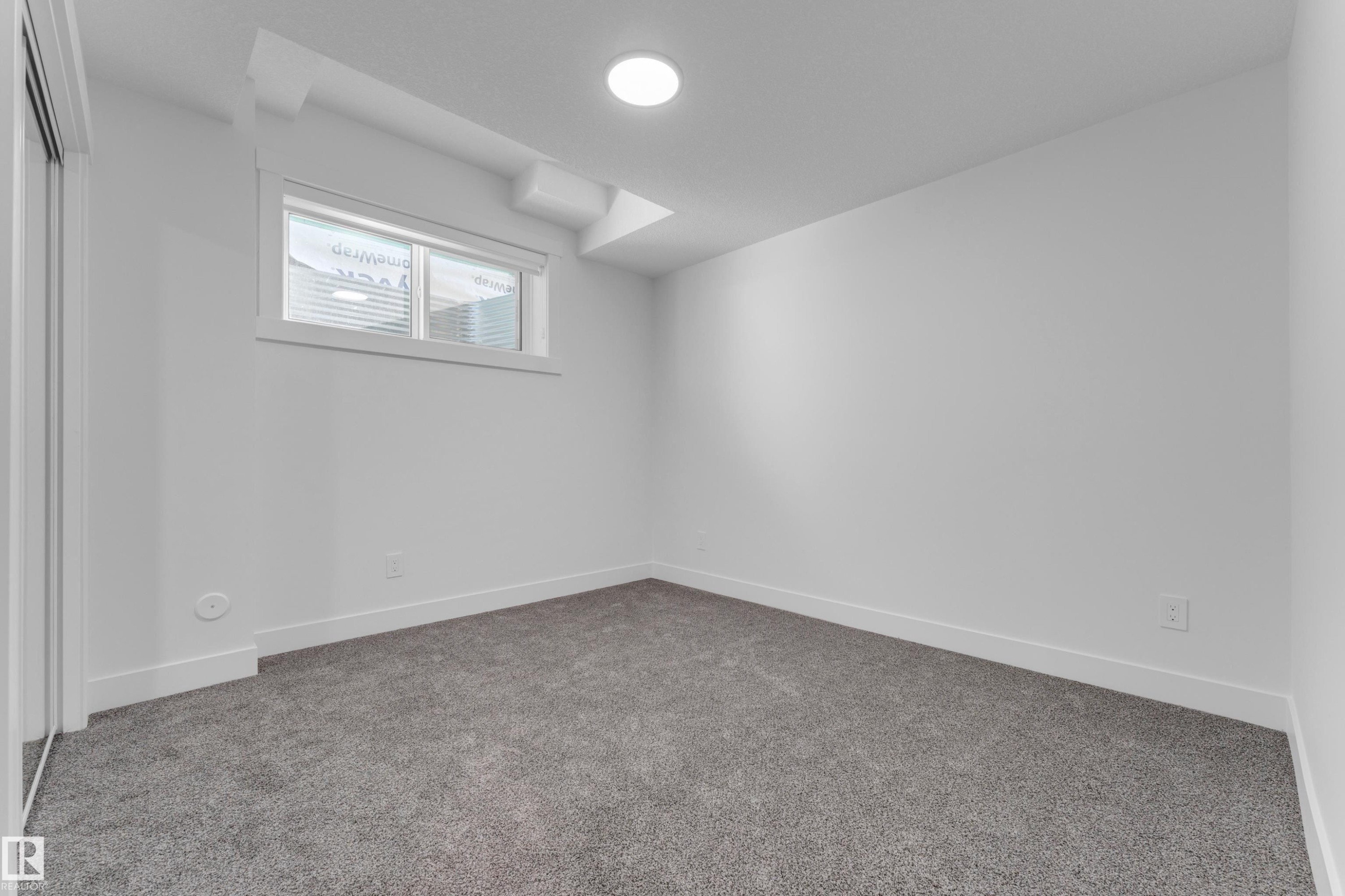 Interior space featuring wall-to-wall gray carpeting, white walls, and white baseboards - 206 Linden Loop, Leduc, AB