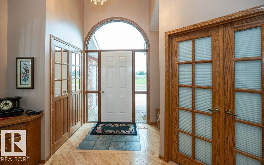Foyer with arched transom window, side panel windows, and a white entry door - 60230 Rg Rd 271, Rural Westlock County, AB