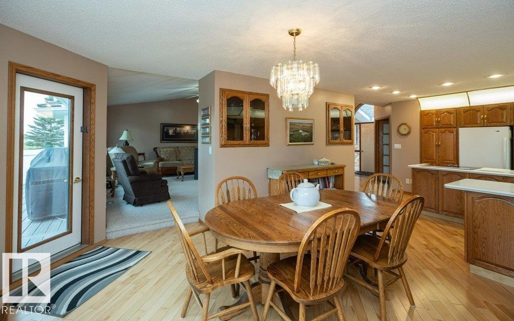 Hardwood-finish flooring throughout, featuring a crystal chandelier in the dining area - 60230 Rg Rd 271, Rural Westlock County, AB