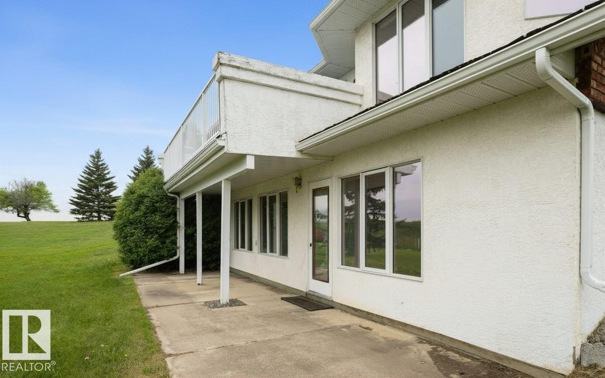 Exterior stucco finish with a ground-level concrete patio - 60230 Rg Rd 271, Rural Westlock County, AB