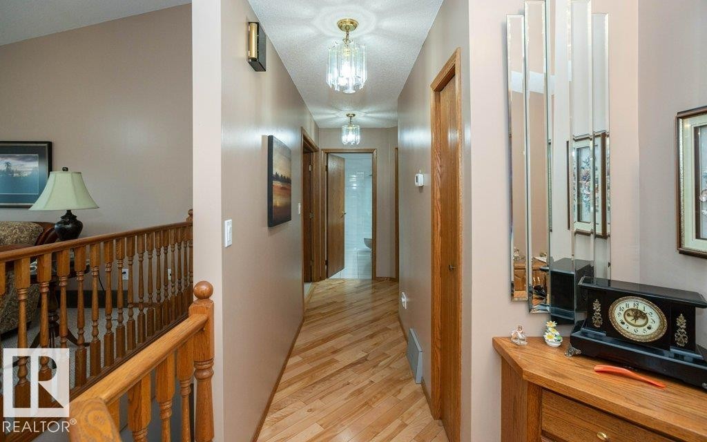 Hallway featuring wood-finish flooring, warm neutral wall tones, and recessed lighting - 60230 Rg Rd 271, Rural Westlock County, AB