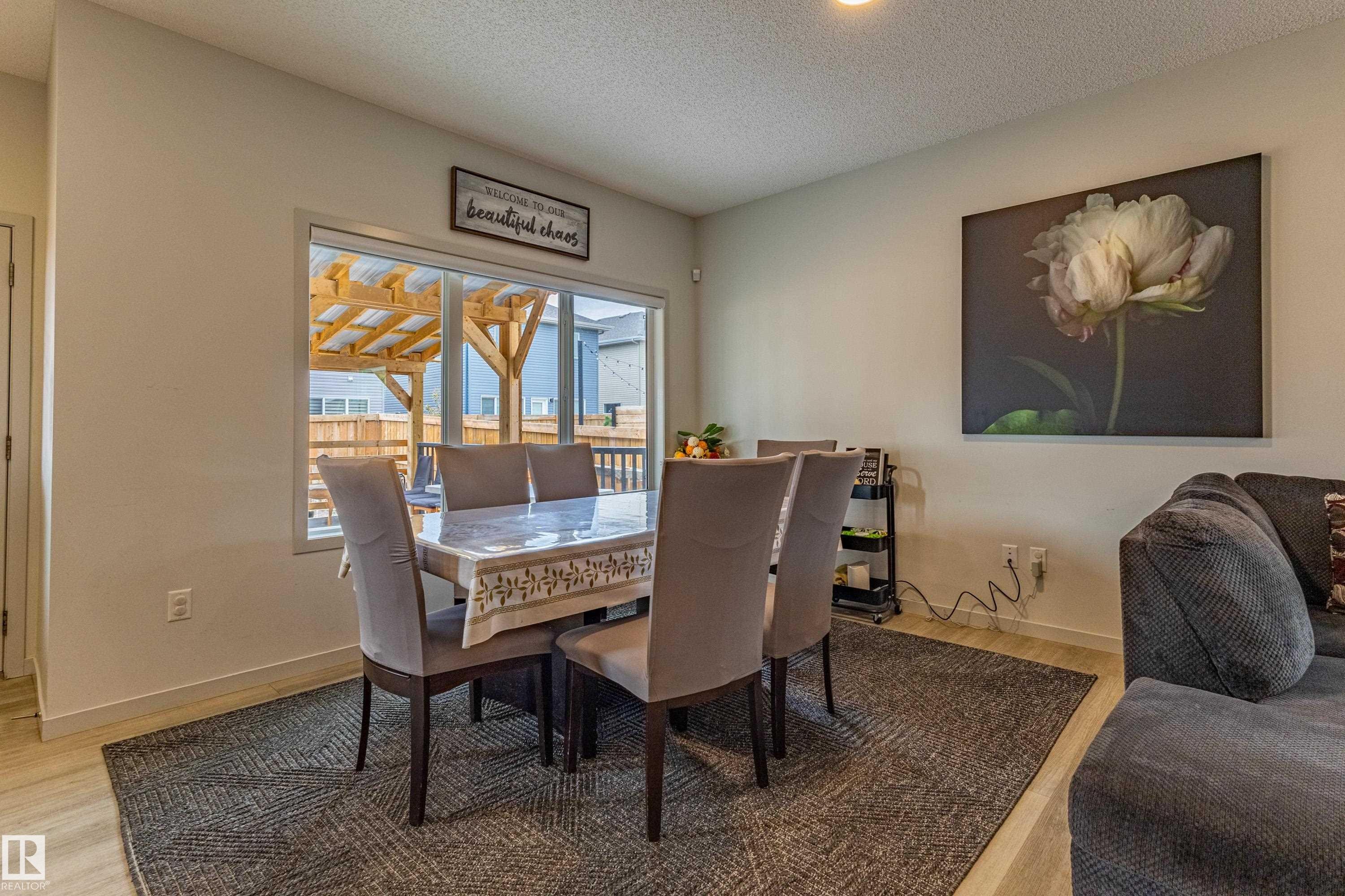 Dining area featuring wood-finish flooring and a large window - 41 Sequoia Bend, Fort Saskatchewan, AB