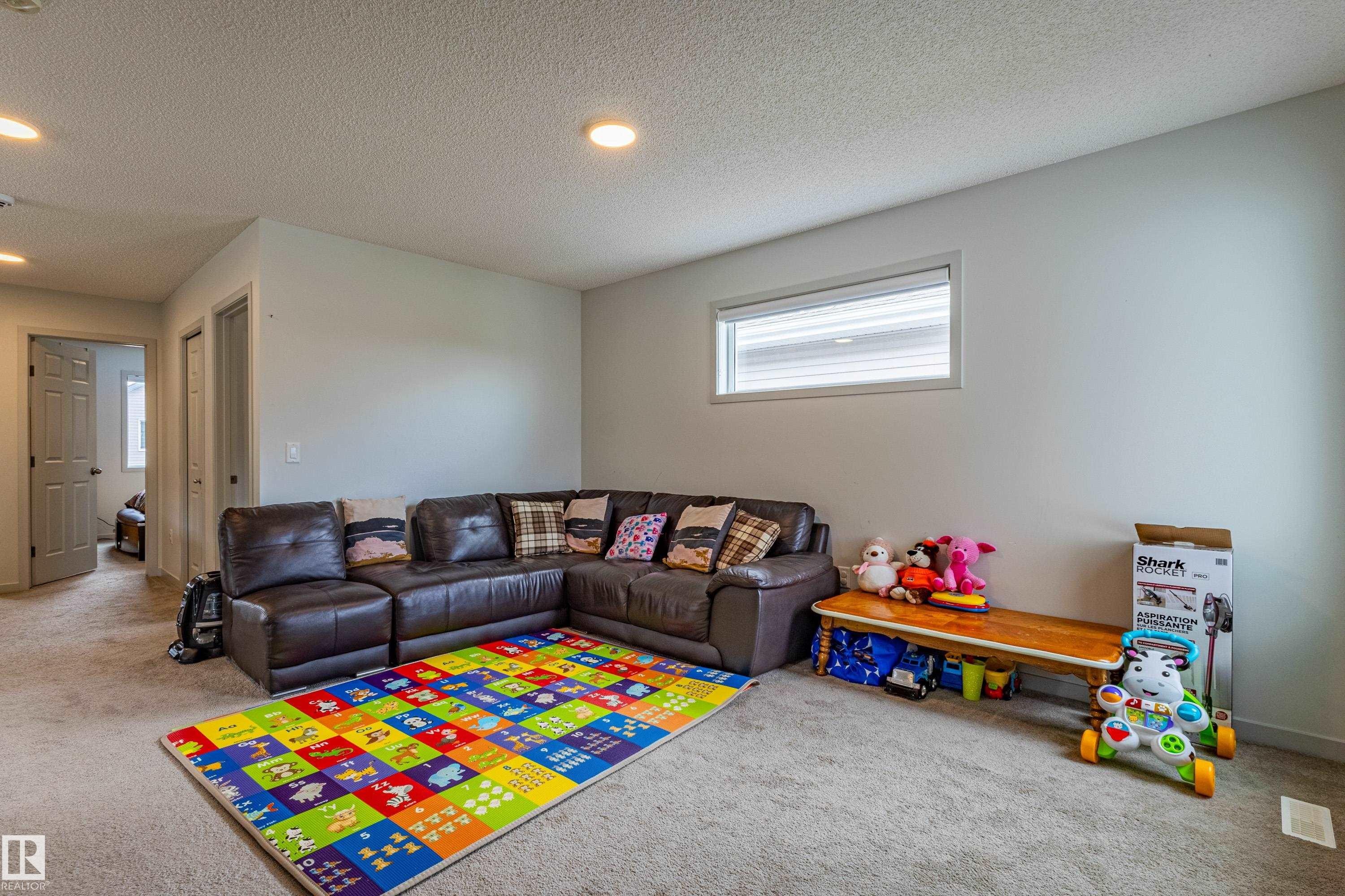 Carpeted interior space featuring light-colored walls and a horizontal window with blinds - 41 Sequoia Bend, Fort Saskatchewan, AB
