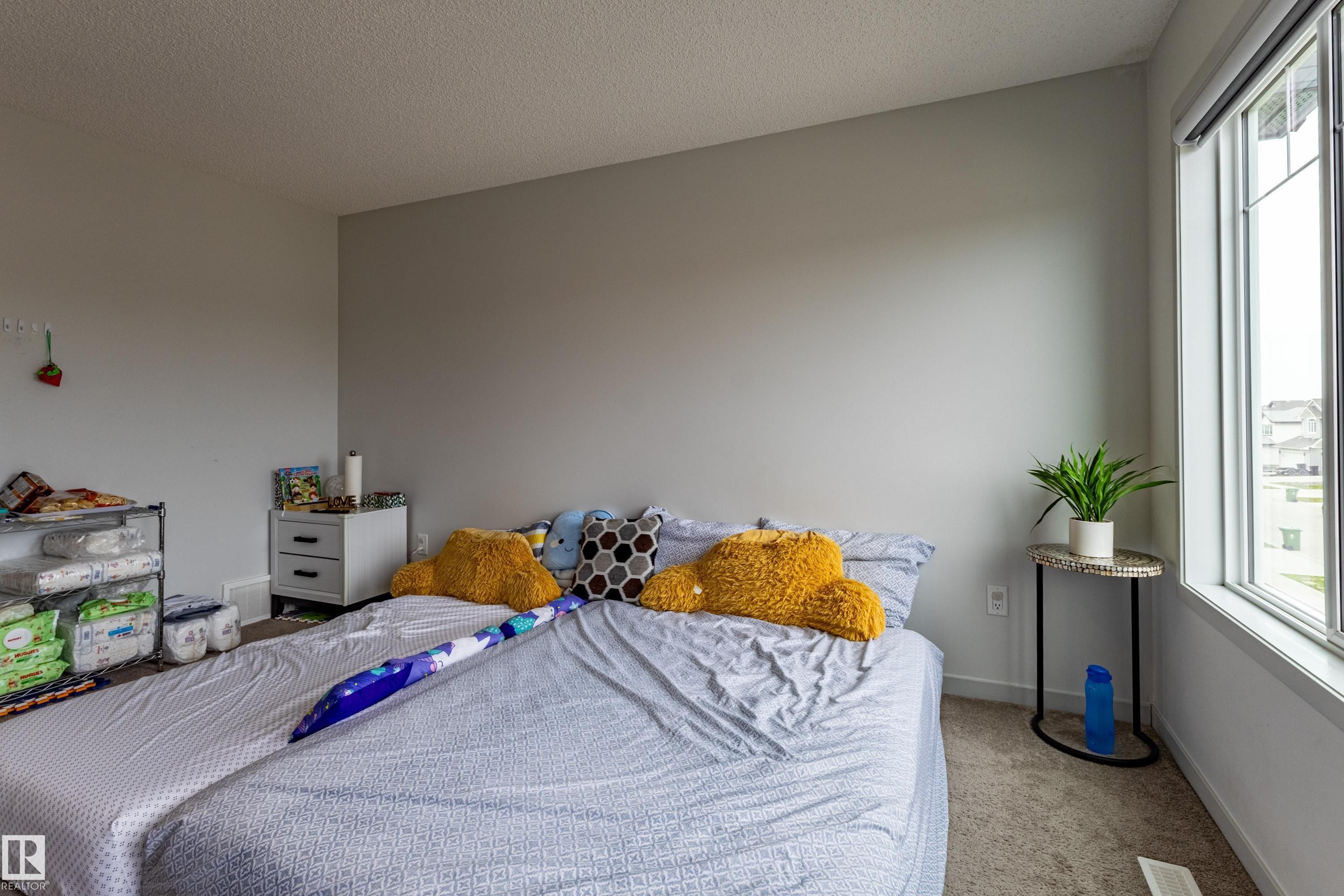 Carpeted room with a large window and neutral wall tones - 41 Sequoia Bend, Fort Saskatchewan, AB