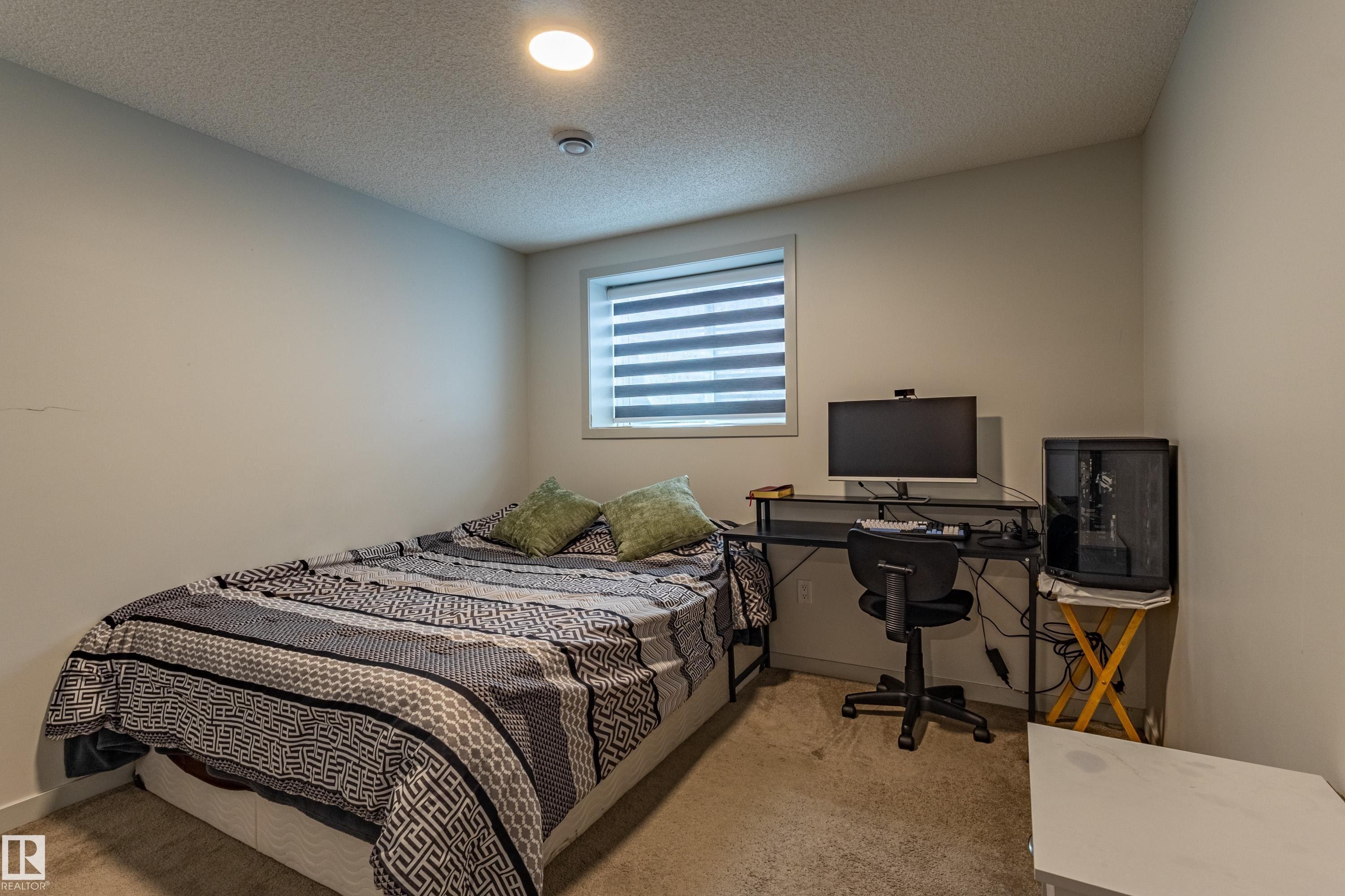 Bedroom featuring light neutral wall paint, a single window with blinds, and recessed ceiling lighting - 41 Sequoia Bend, Fort Saskatchewan, AB