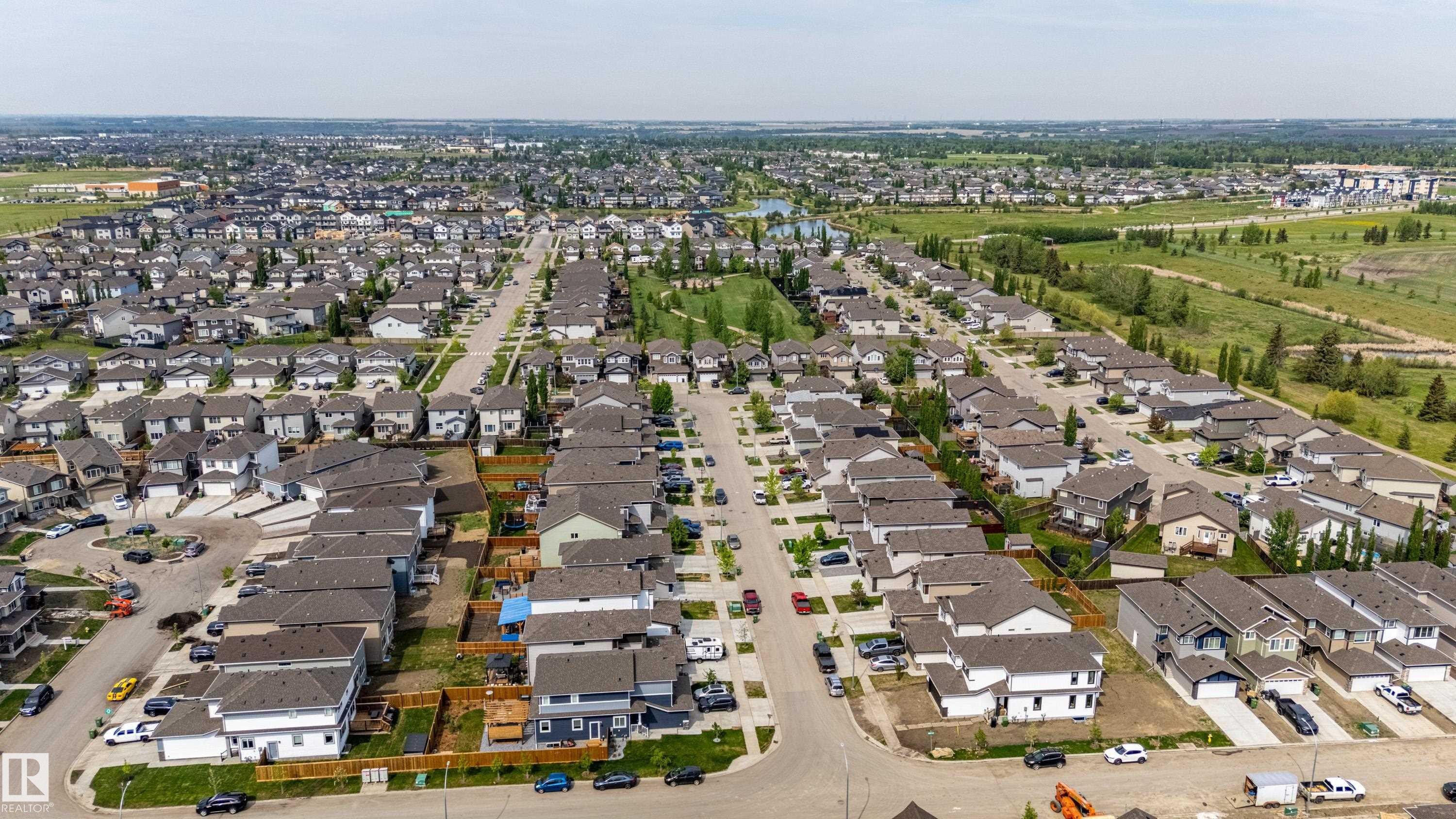 Aerial perspective showcasing a residential neighborhood with diverse housing styles, paved streets, and green spaces - 41 Sequoia Bend, Fort Saskatchewan, AB