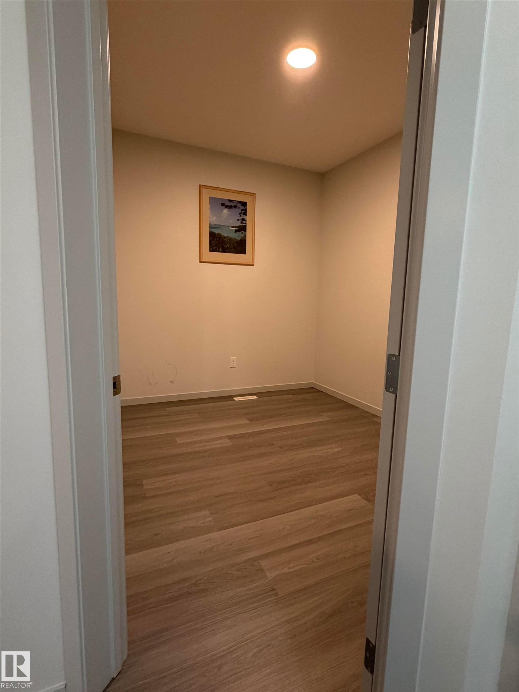 Interior room featuring wood-finish flooring, recessed ceiling lighting, and light-toned wall paint - 41 Sequoia Bend, Fort Saskatchewan, AB - Indoor Photo Showing Other Room