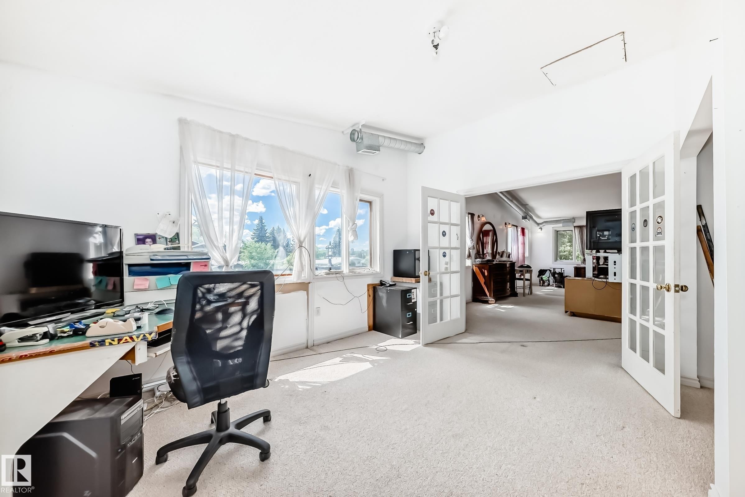 Room featuring light-colored carpeting, multiple windows providing natural light, and white walls - 6804 102A Avenue, Edmonton, AB