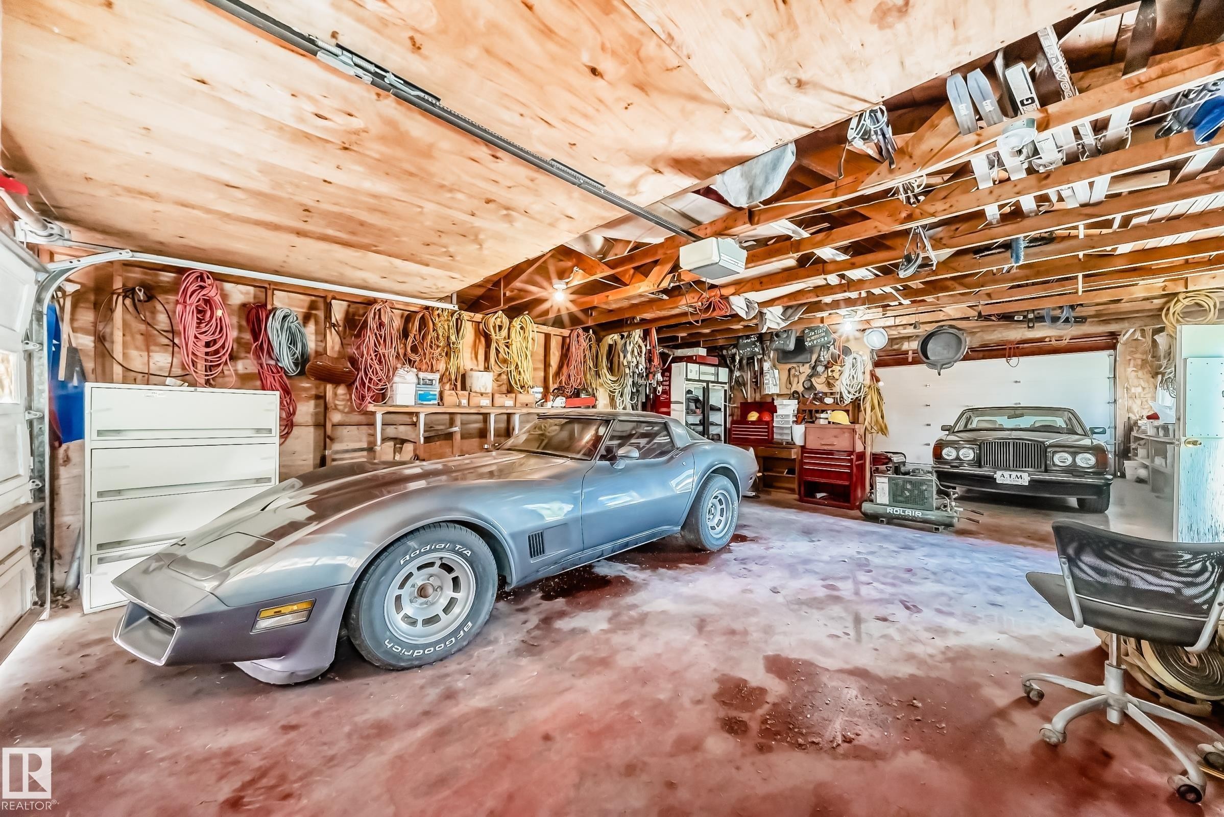 Garage interior featuring exposed wood ceiling beams and wood paneling - 6804 102A Avenue, Edmonton, AB