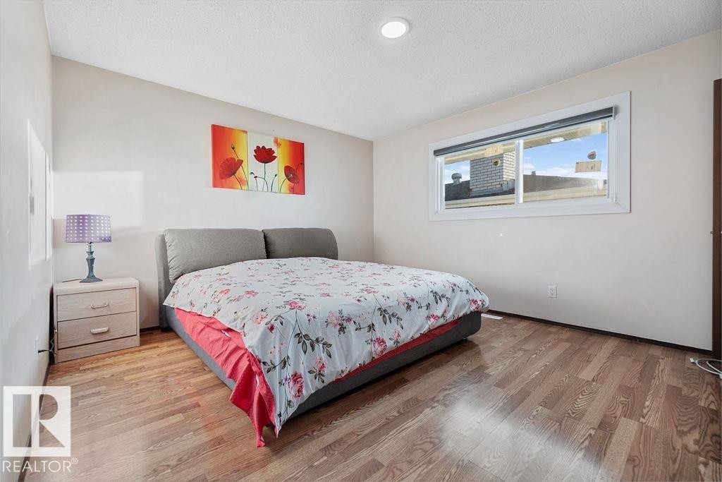 Bedroom featuring wood-finish flooring, a contemporary window, and a recessed ceiling light - 712 Lee Ridge Road, Edmonton, AB