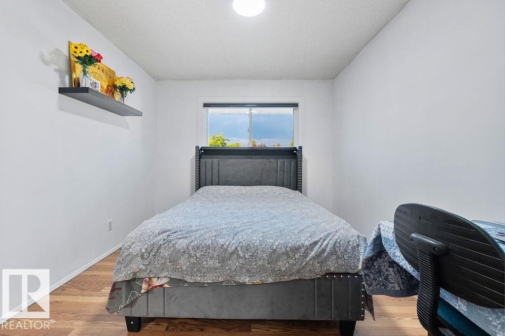 Bright room featuring wood-finish flooring, a window, and a built-in wall shelf - 712 Lee Ridge Road, Edmonton, AB