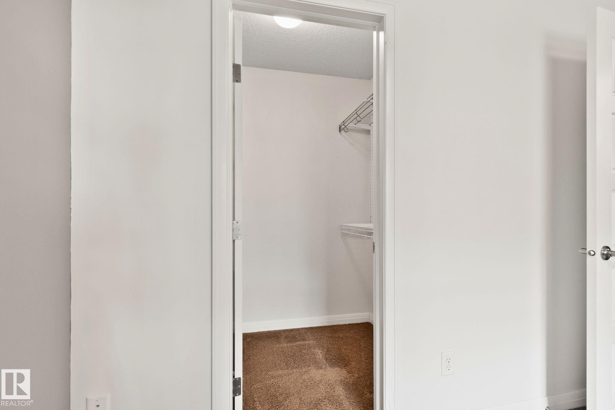 Walk-in closet with wire shelving system and carpet flooring - 217 2588 Anderson Way, Edmonton, AB