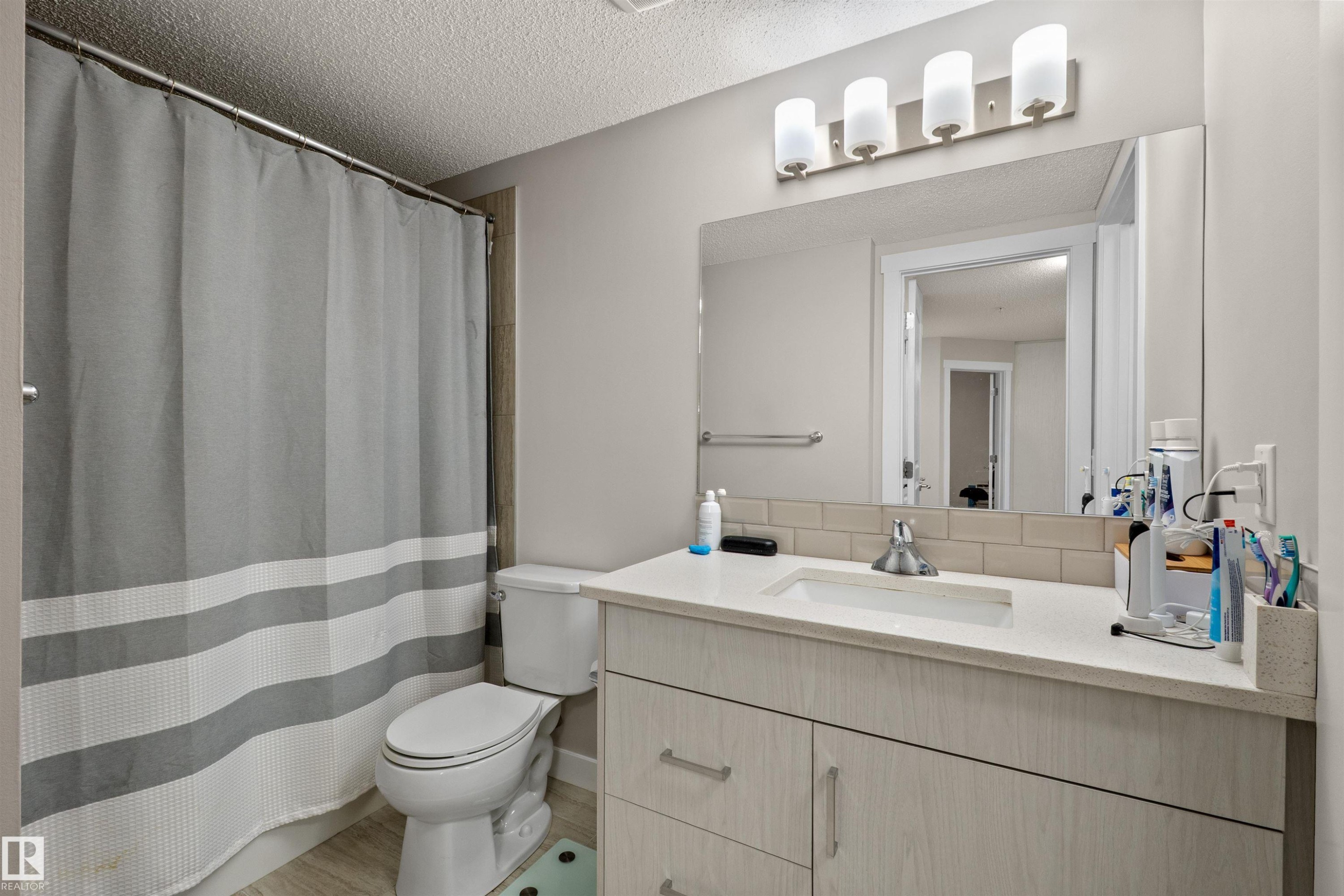 Bathroom featuring a light wood-finish vanity with a white countertop and integrated sink - 210 2229 44 Avenue, Edmonton, AB