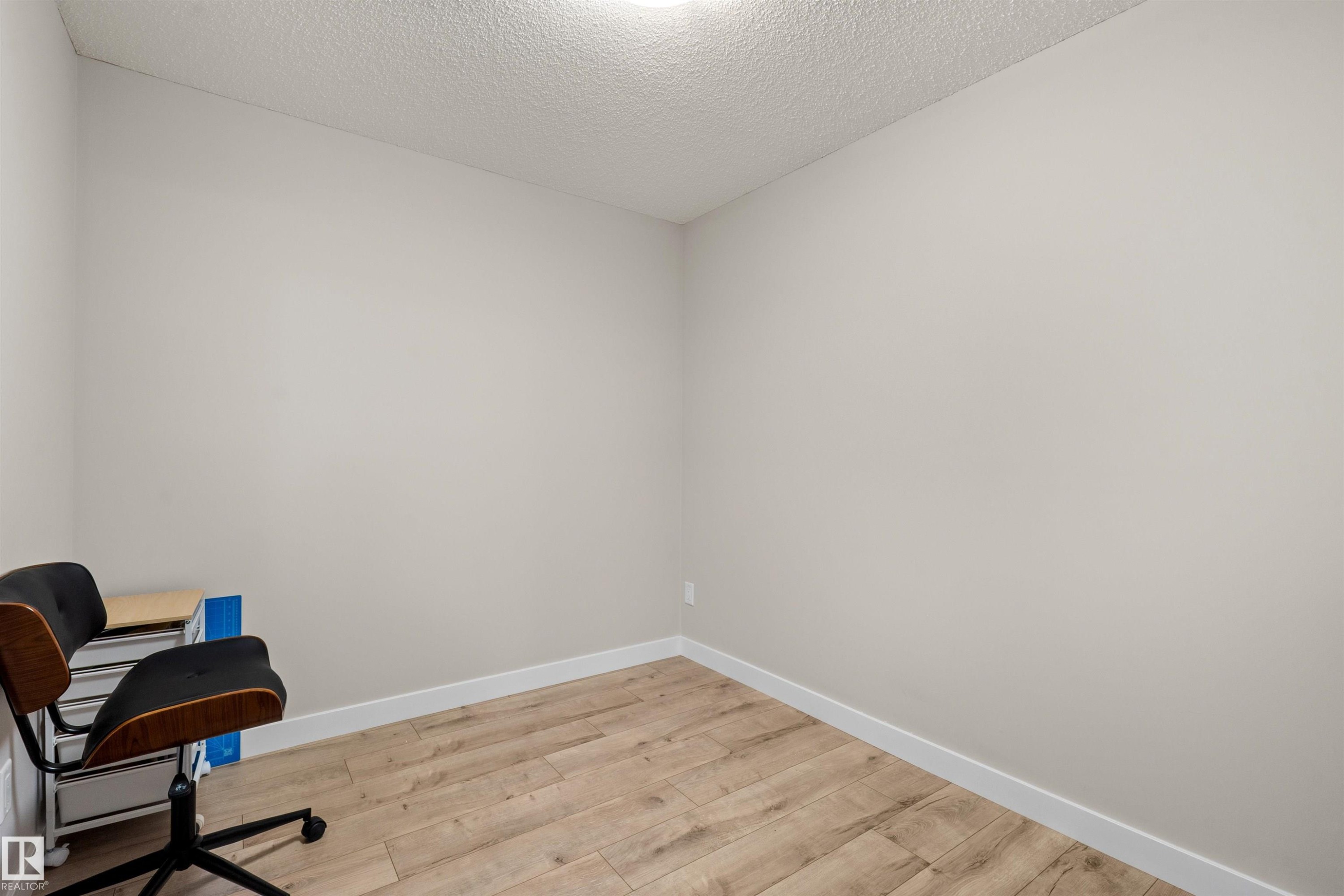 Neutral-toned walls complement the wood-finish flooring - 210 2229 44 Avenue, Edmonton, AB