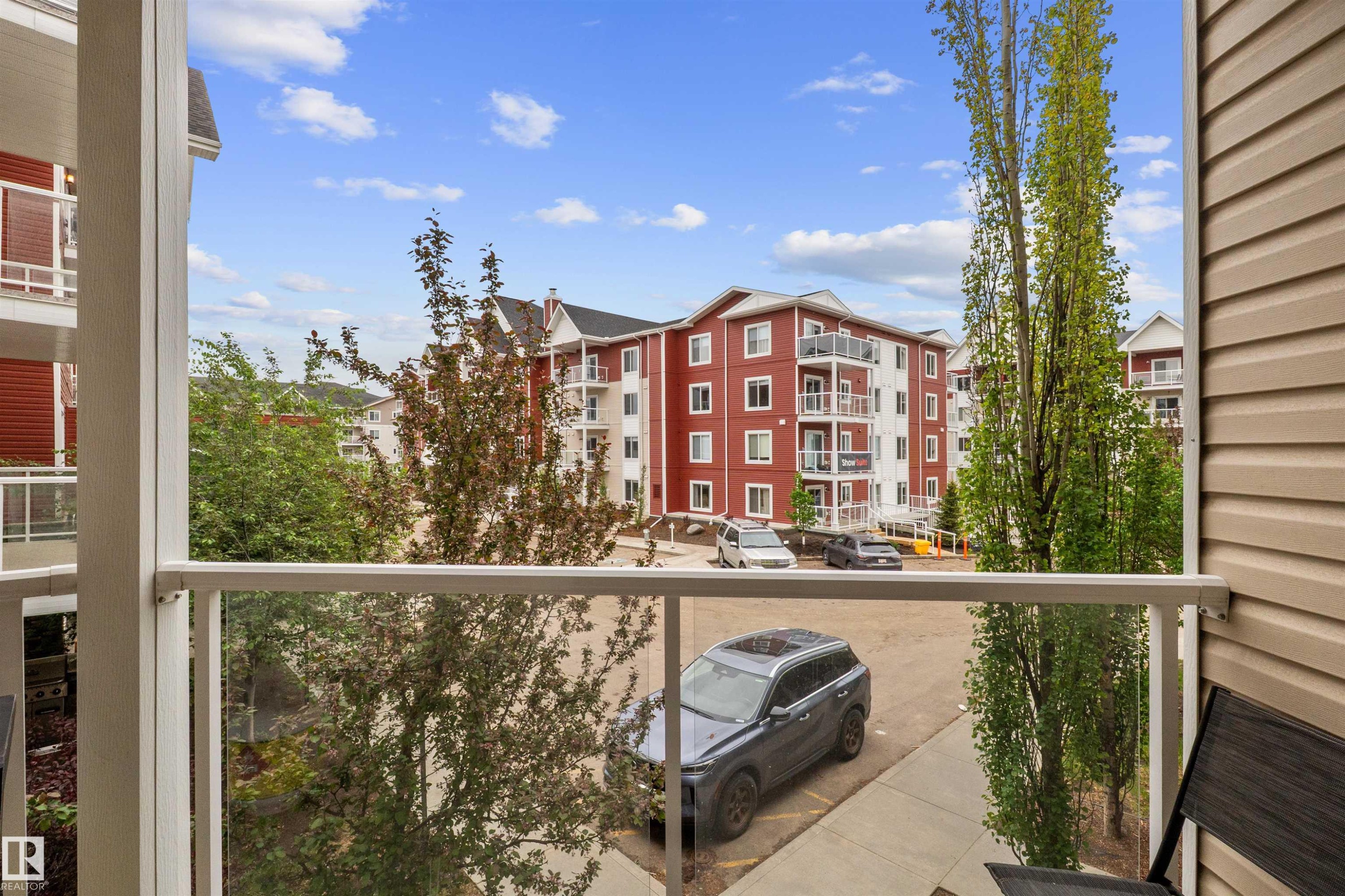 Balcony featuring glass panel railing and vinyl siding - 210 2229 44 Avenue, Edmonton, AB