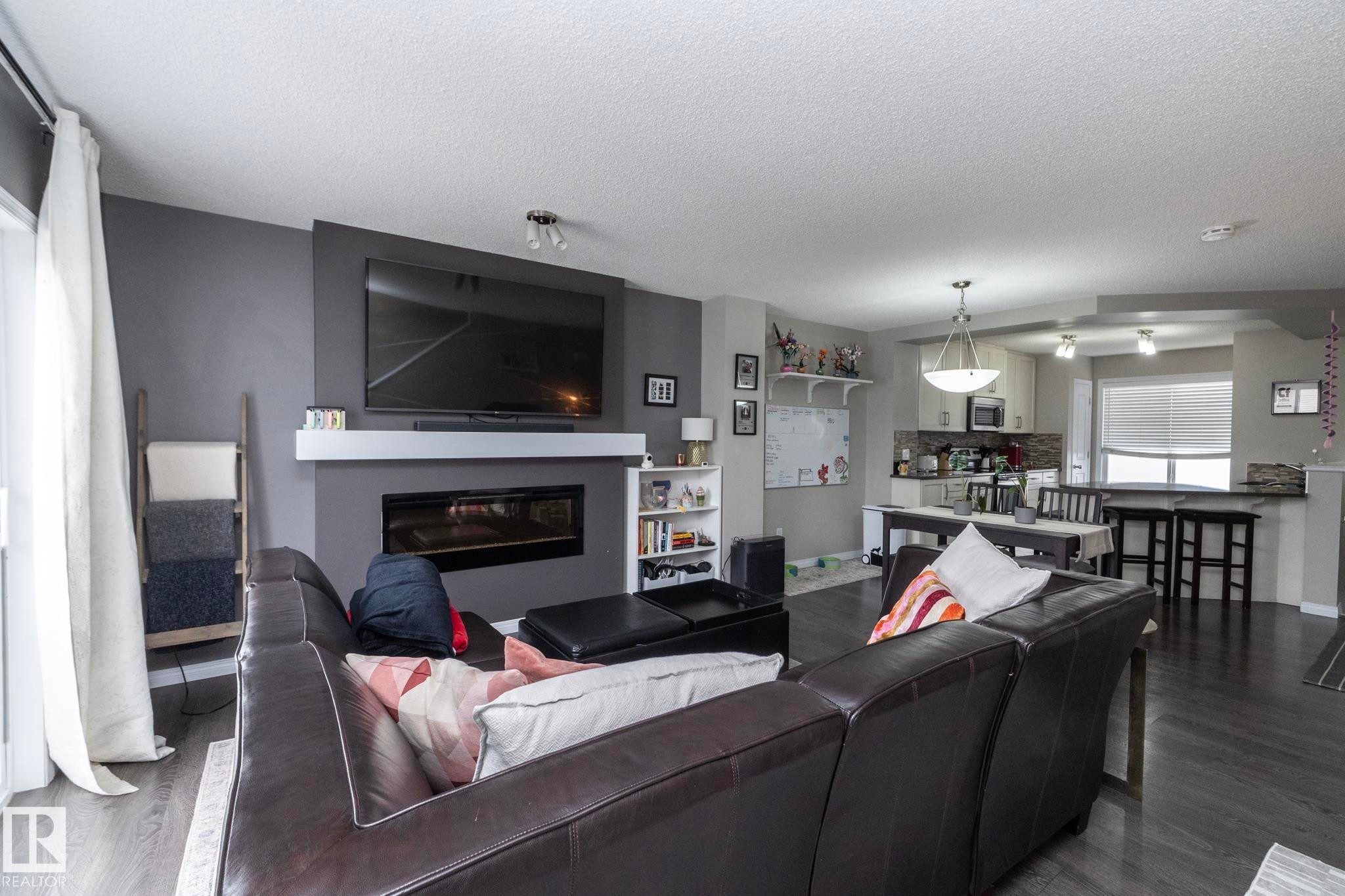 Open-concept living space featuring wood-finish flooring - 46 4050 Savaryn Drive, Edmonton, AB