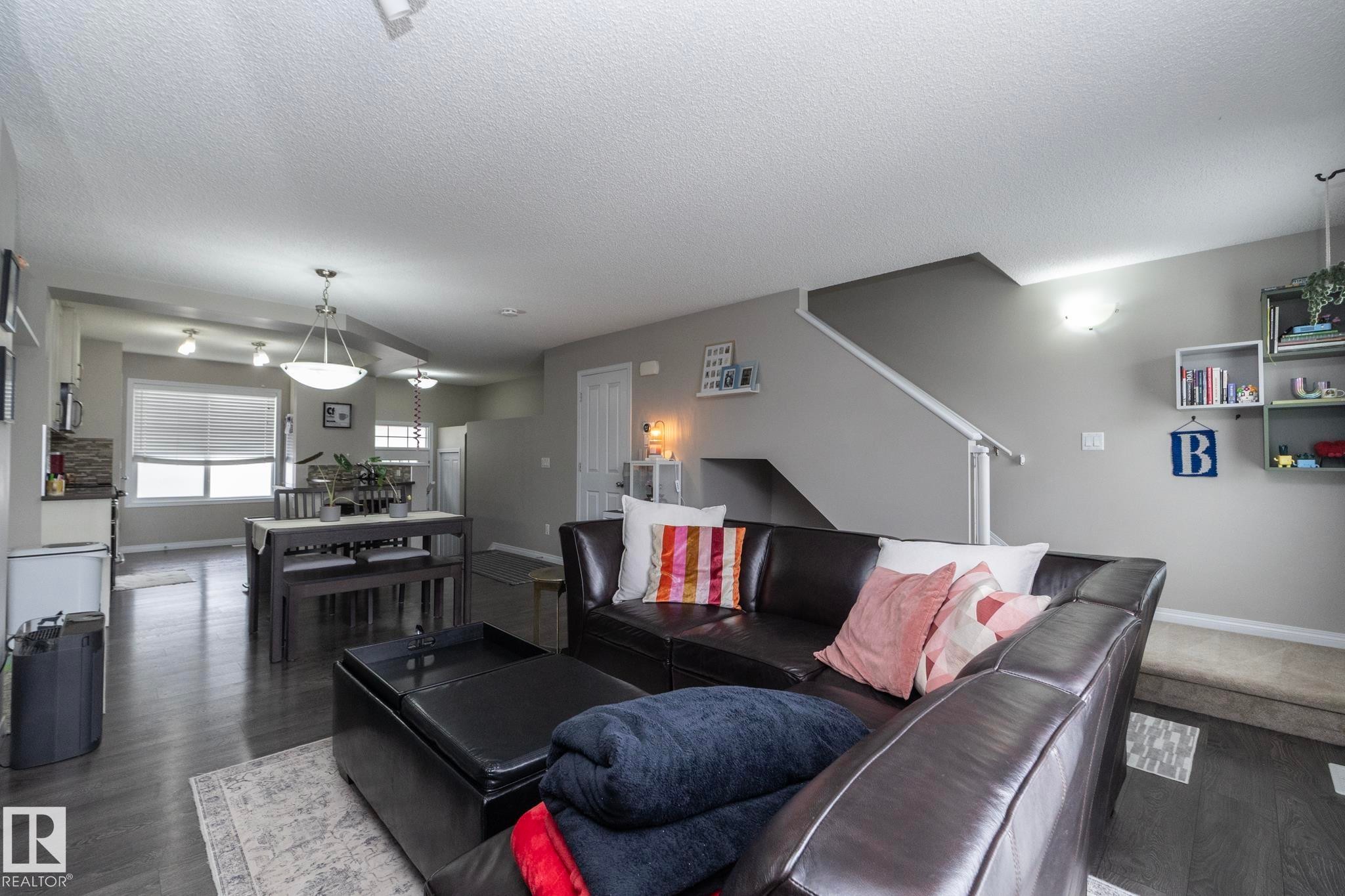 Open-concept living area featuring dark wood-finish flooring - 46 4050 Savaryn Drive, Edmonton, AB