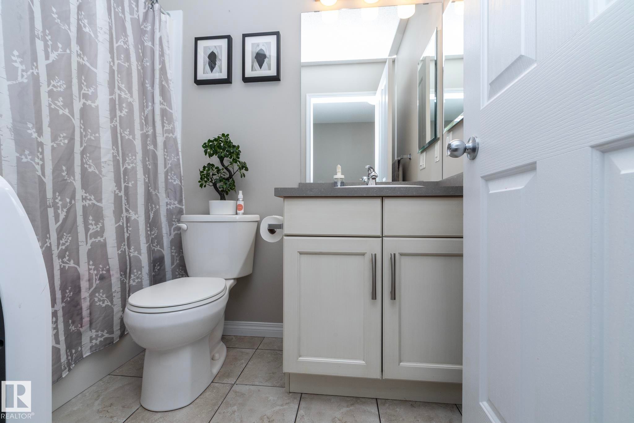 Bathroom featuring a single vanity with light cabinetry, a contrasting countertop, and an integrated sink - 46 4050 Savaryn Drive, Edmonton, AB