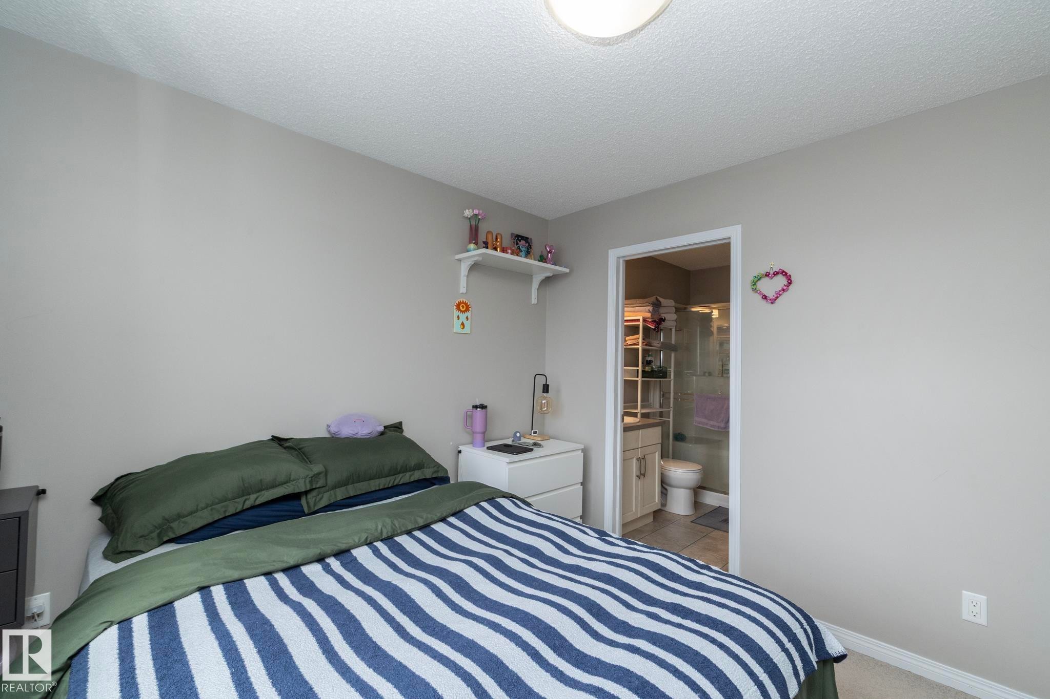 Neutral wall paint, ceiling-mounted light fixture, and textured ceiling - 46 4050 Savaryn Drive, Edmonton, AB