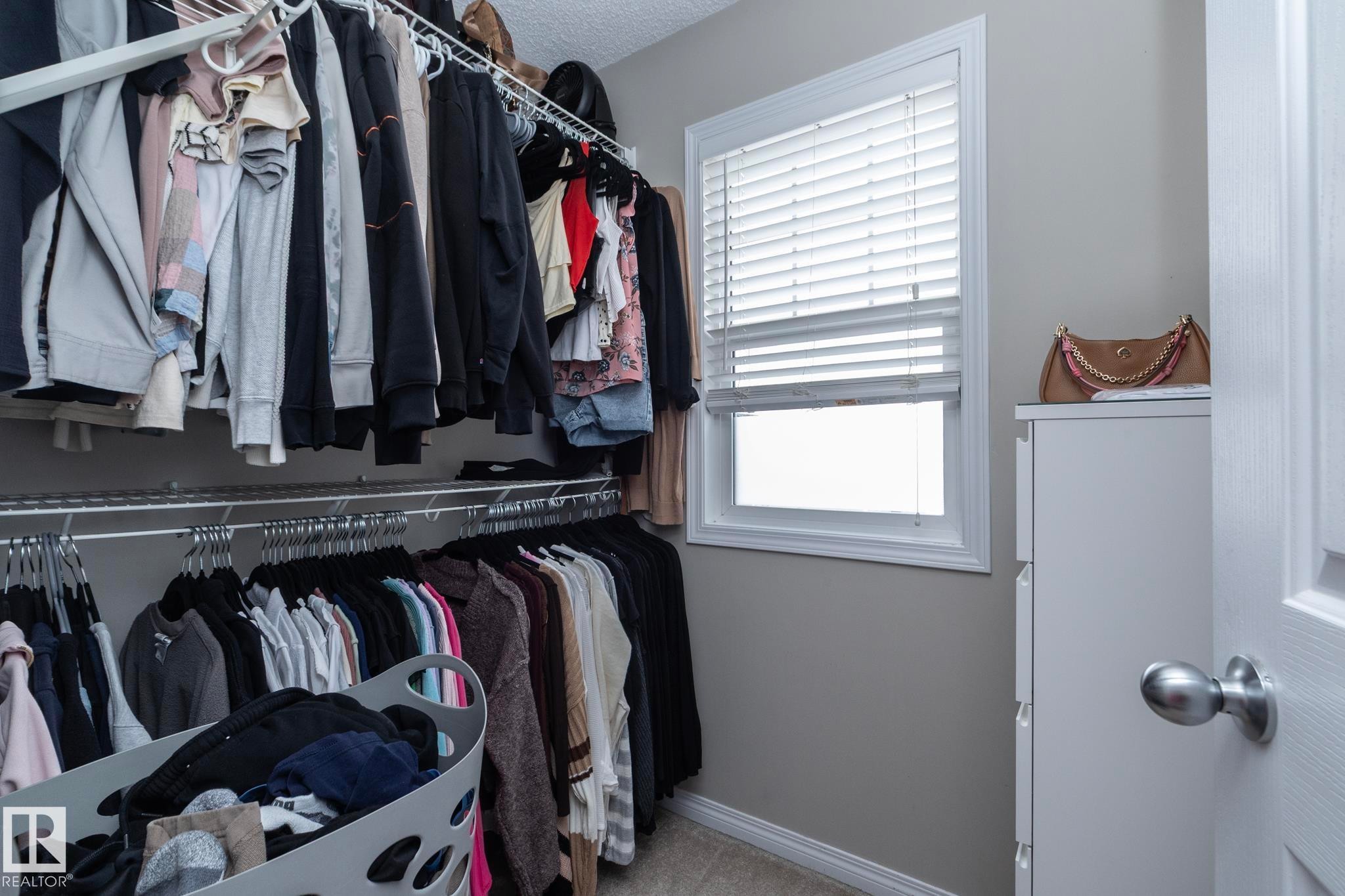 Custom closet system featuring multiple hanging rods and shelving - 46 4050 Savaryn Drive, Edmonton, AB