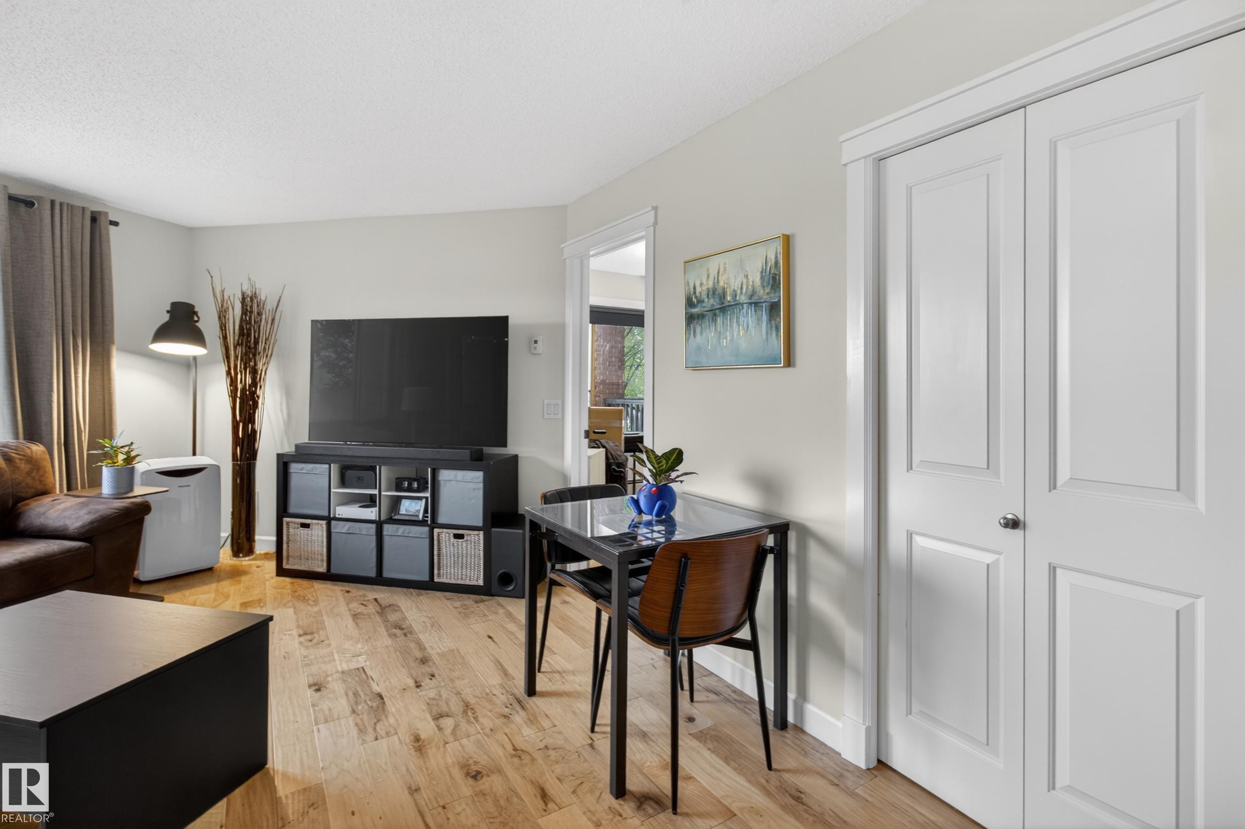 Open-concept living area with light-toned walls and wood-finish flooring - 211 3719 Whitelaw Lane, Edmonton, AB