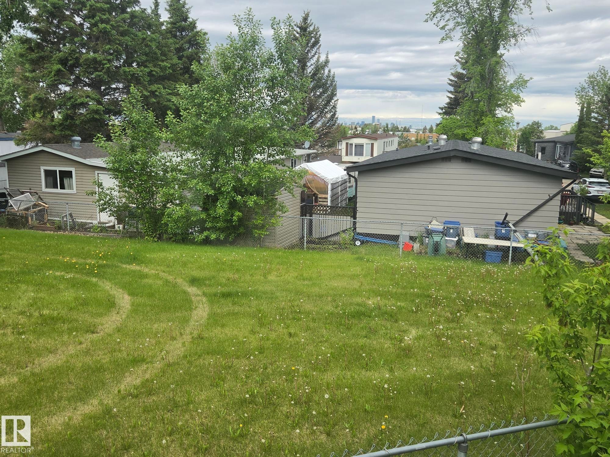 Expansive green lawn with mature trees and partial fencing - 14 Willowdale Drive, Edmonton, AB