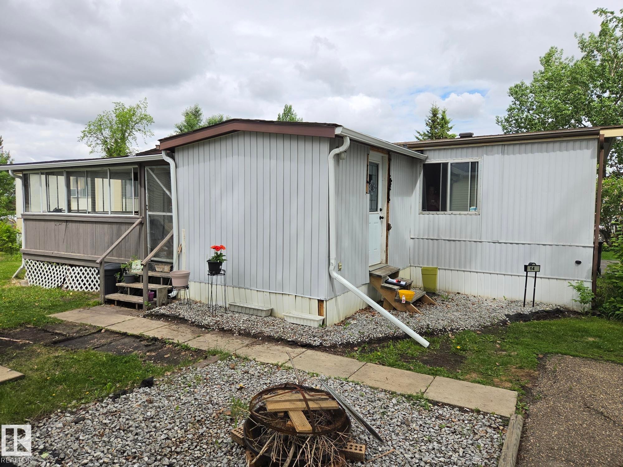Exterior featuring white vertical siding, brown roofline, and a screened-in porch with wood-look siding - 14 Willowdale Drive, Edmonton, AB