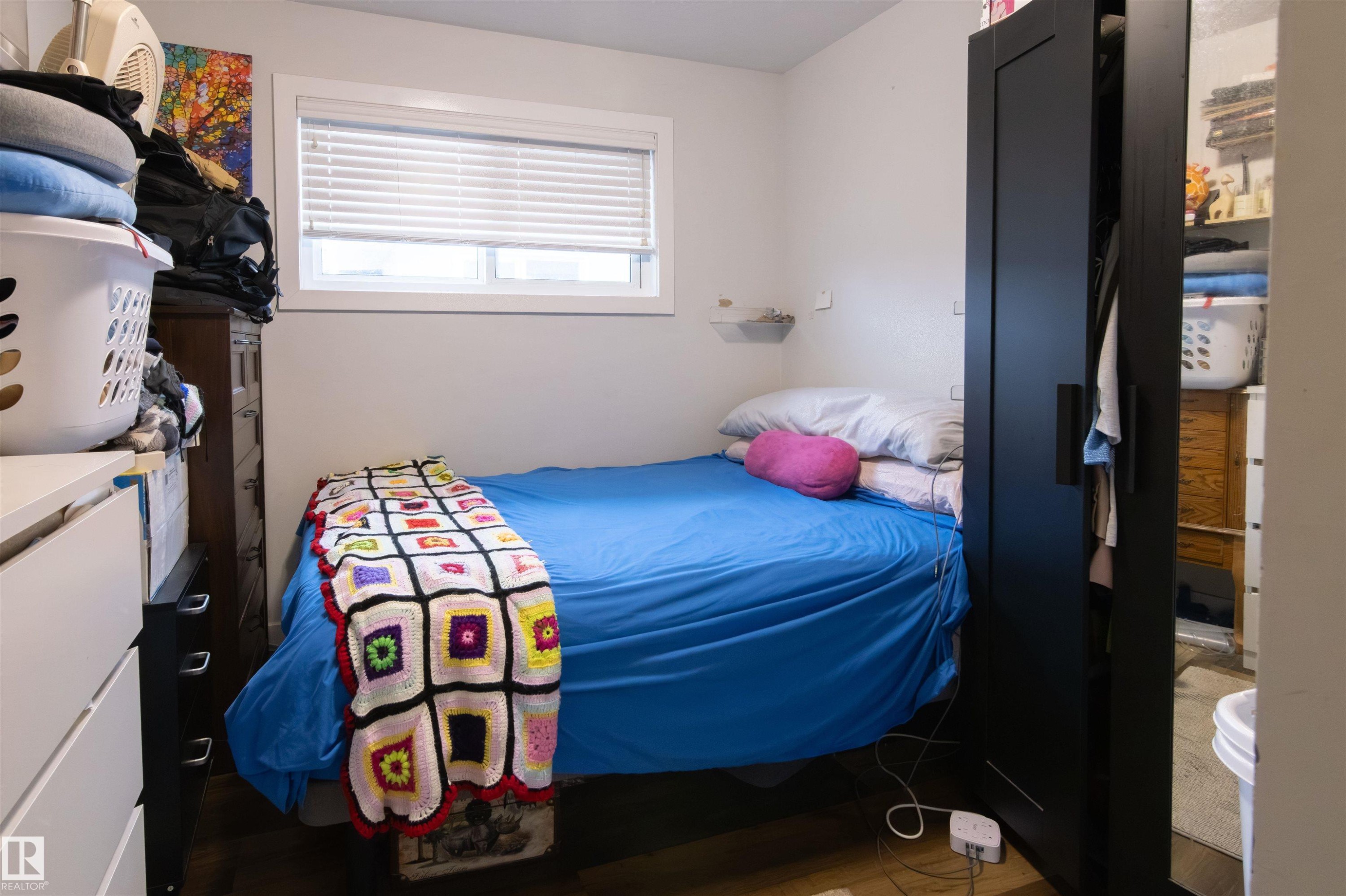 White walls with a single window featuring horizontal blinds - 4004 88 Street Nw, Edmonton, AB - Indoor Photo Showing Bedroom