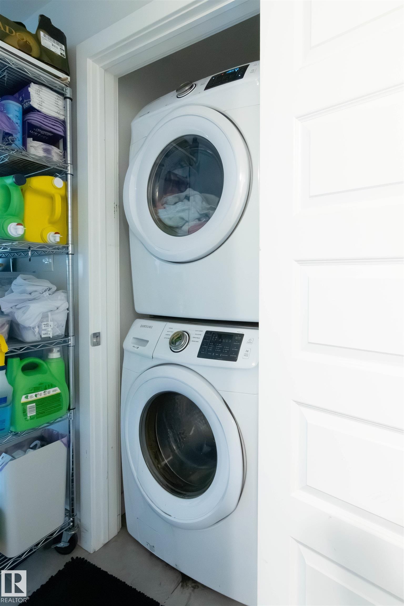 Dedicated laundry alcove featuring a stacked washer and dryer unit - 4004 88 Street Nw, Edmonton, AB - Indoor Photo Showing Laundry Room
