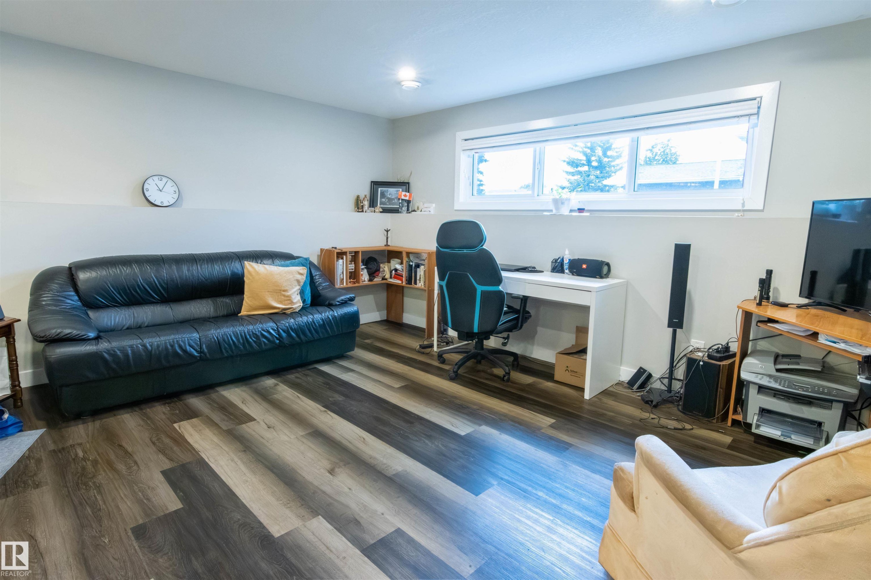 Spacious room featuring multi-tone wood-finish flooring, a contemporary window, recessed lighting, and a neutral color palette - 4004 88 Street Nw, Edmonton, AB - Indoor