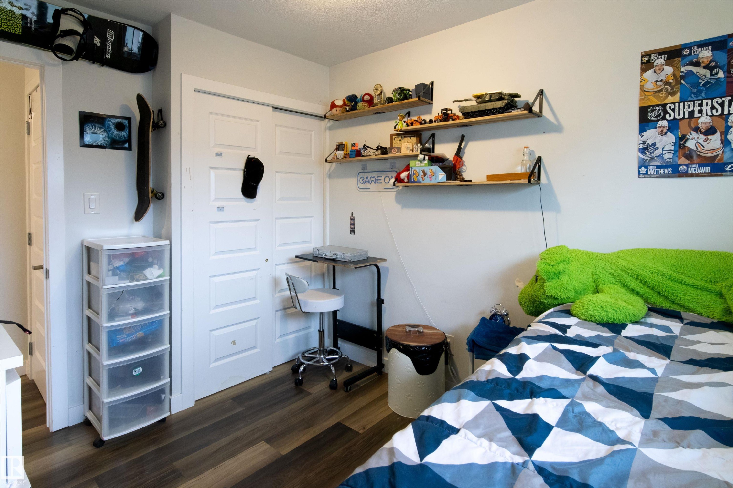 Bedroom featuring wood-finish flooring, white walls, and a bi-fold closet door - 4004 88 Street Nw, Edmonton, AB - Indoor Photo Showing Bedroom