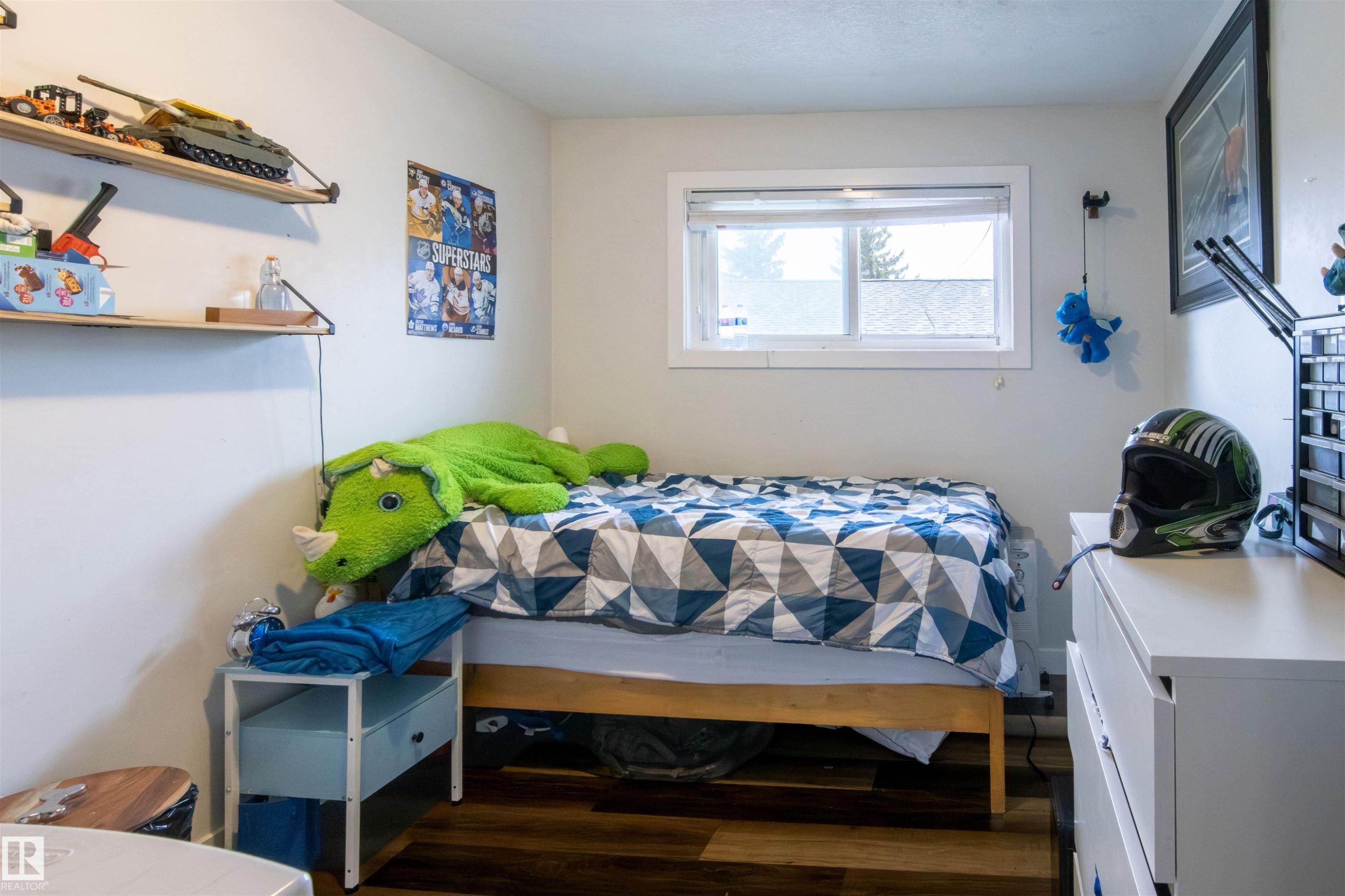 Bedroom featuring wood-finish flooring, a window with white trim, and light-toned walls - 4004 88 Street Nw, Edmonton, AB - Indoor Photo Showing Bedroom