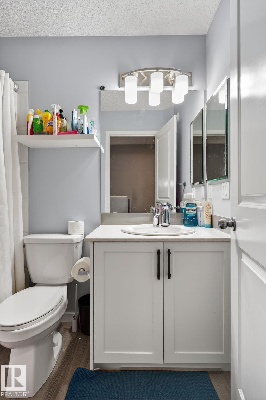 Bathroom with a white vanity featuring a built-in sink, chrome faucet, and quartz countertop - 62 3305 Orchards Link, Edmonton, AB