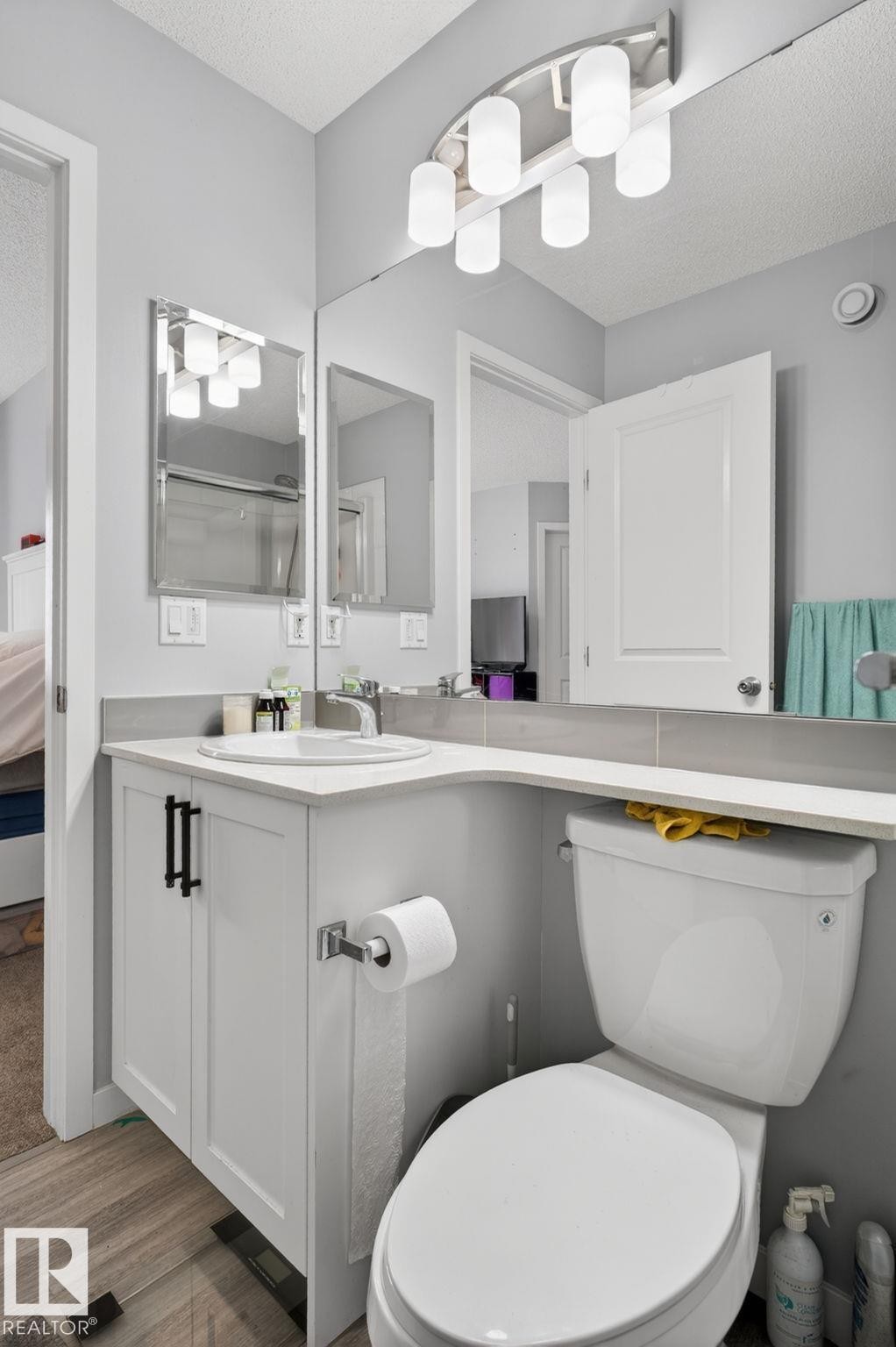 Modern bathroom featuring a white vanity with black hardware, a rectangular sink, and a light-toned countertop - 62 3305 Orchards Link, Edmonton, AB