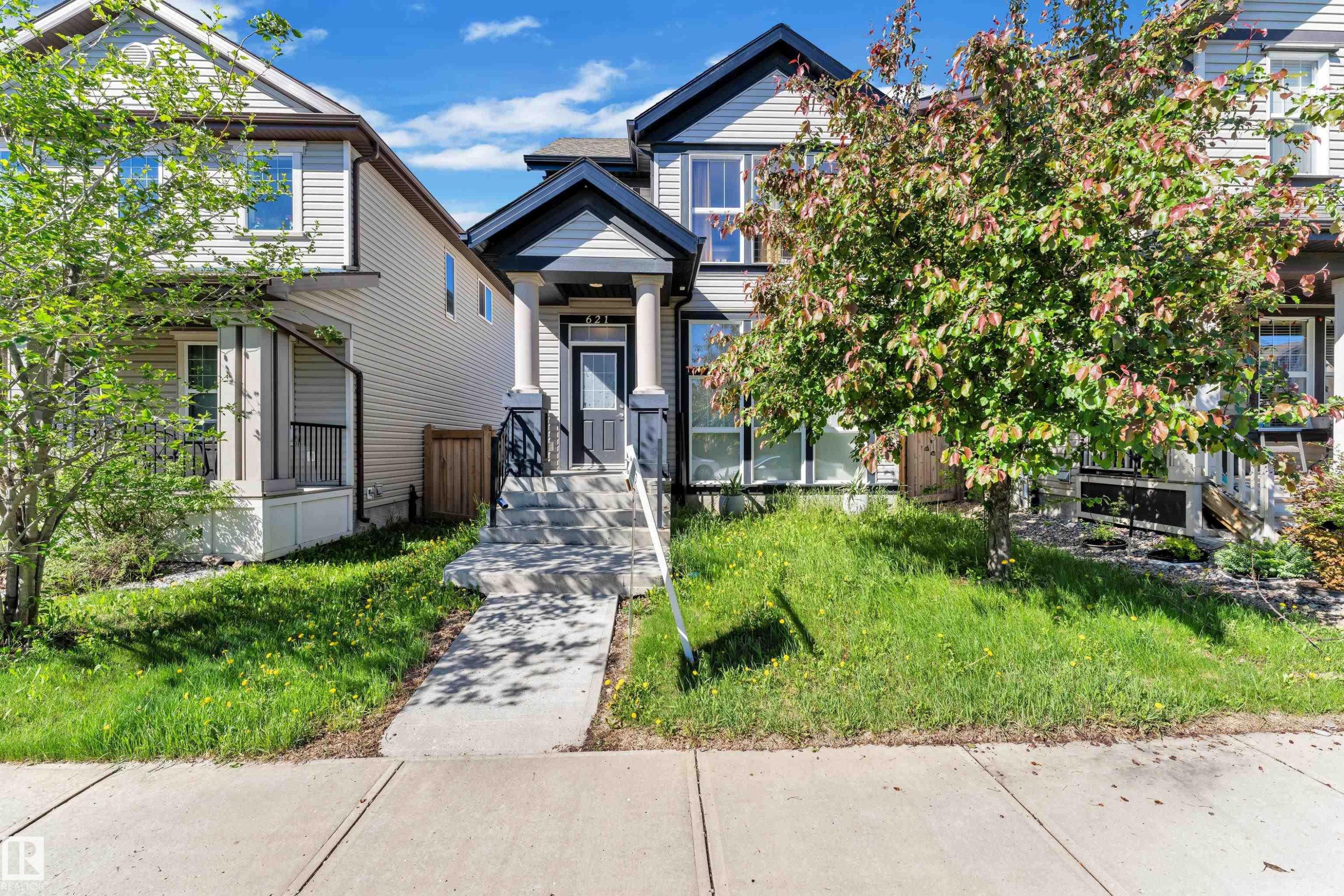Two-story home with a dark-trimmed gable roofline and light-toned siding - 621 Mcdonough Link Link, Edmonton, AB