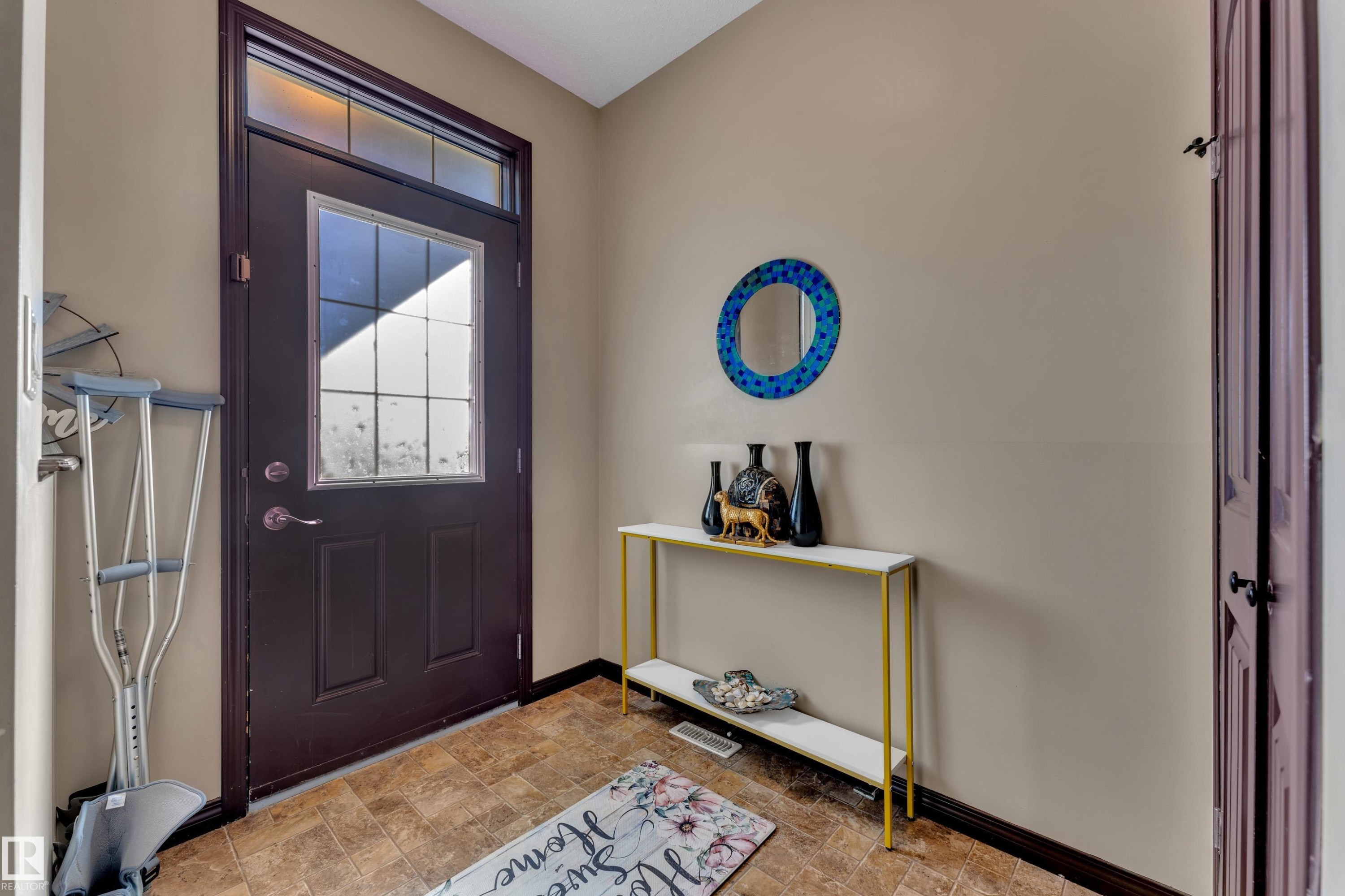 Entryway featuring a dark paneled door with glass inserts and transom window - 621 Mcdonough Link Link, Edmonton, AB