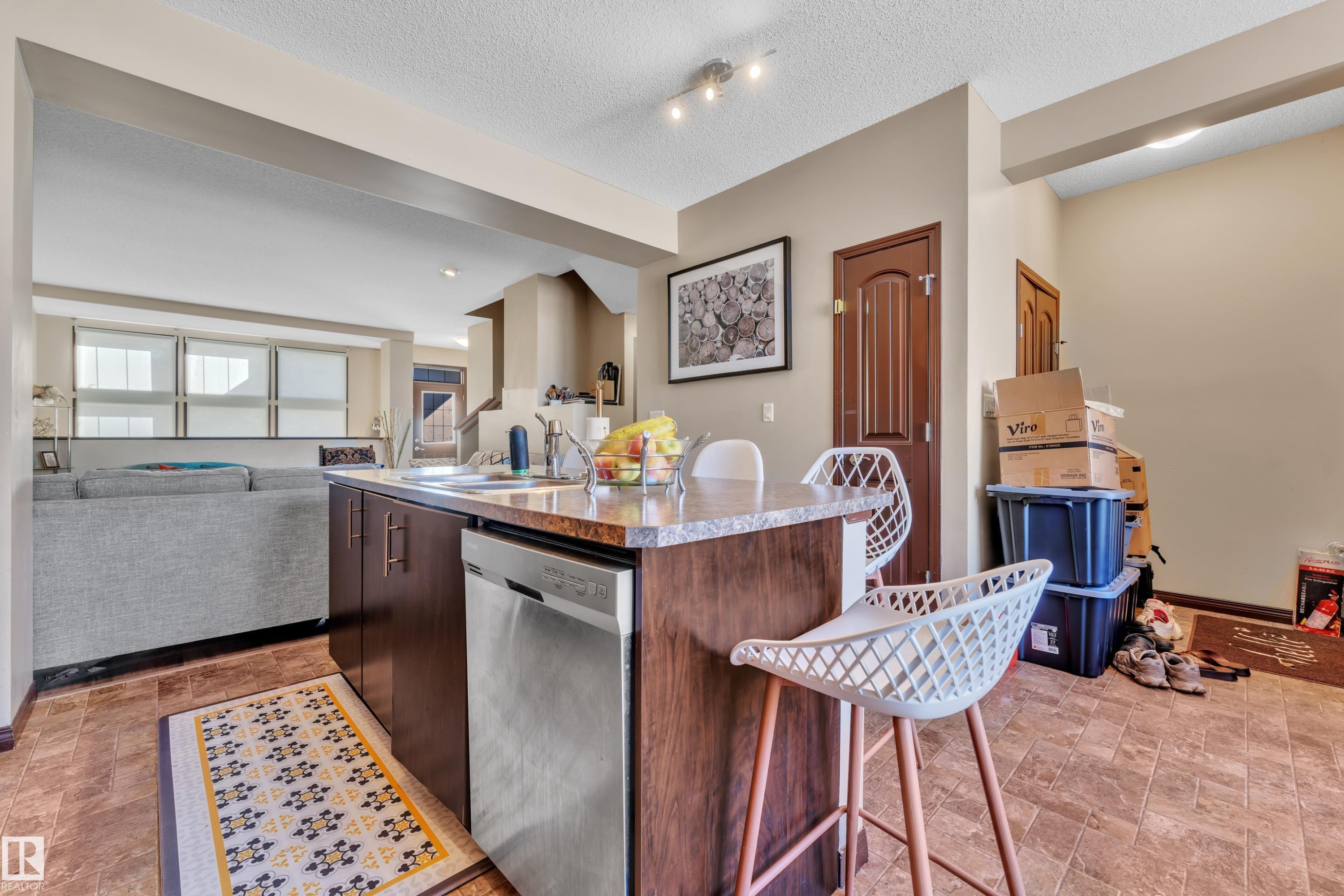 Kitchen island with a built-in stainless steel dishwasher, an undermount sink, and a granite-finish countertop - 621 Mcdonough Link Link, Edmonton, AB