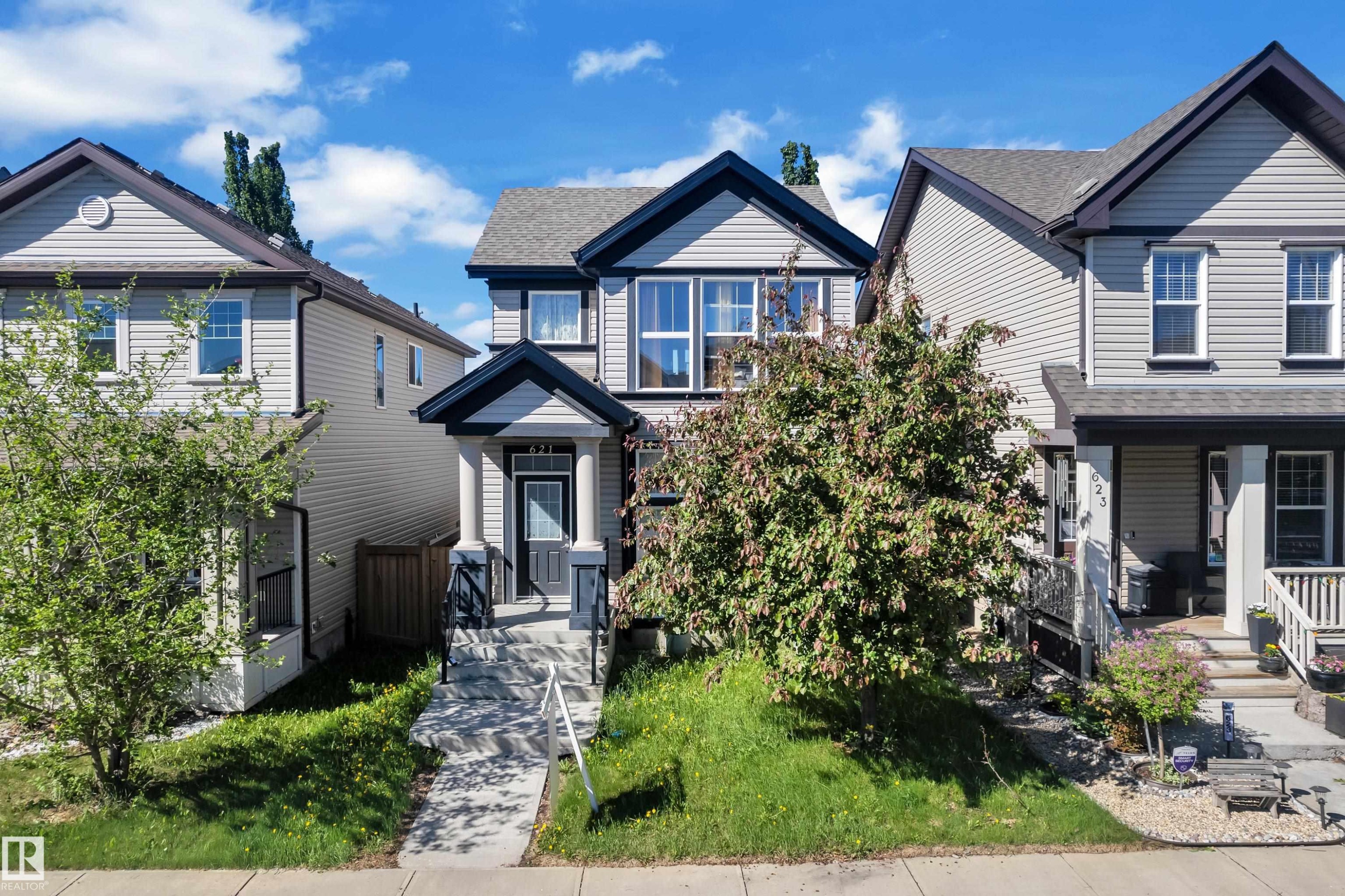 Grey siding exterior with black trim accents and a covered front porch featuring white columns - 621 Mcdonough Link Link, Edmonton, AB