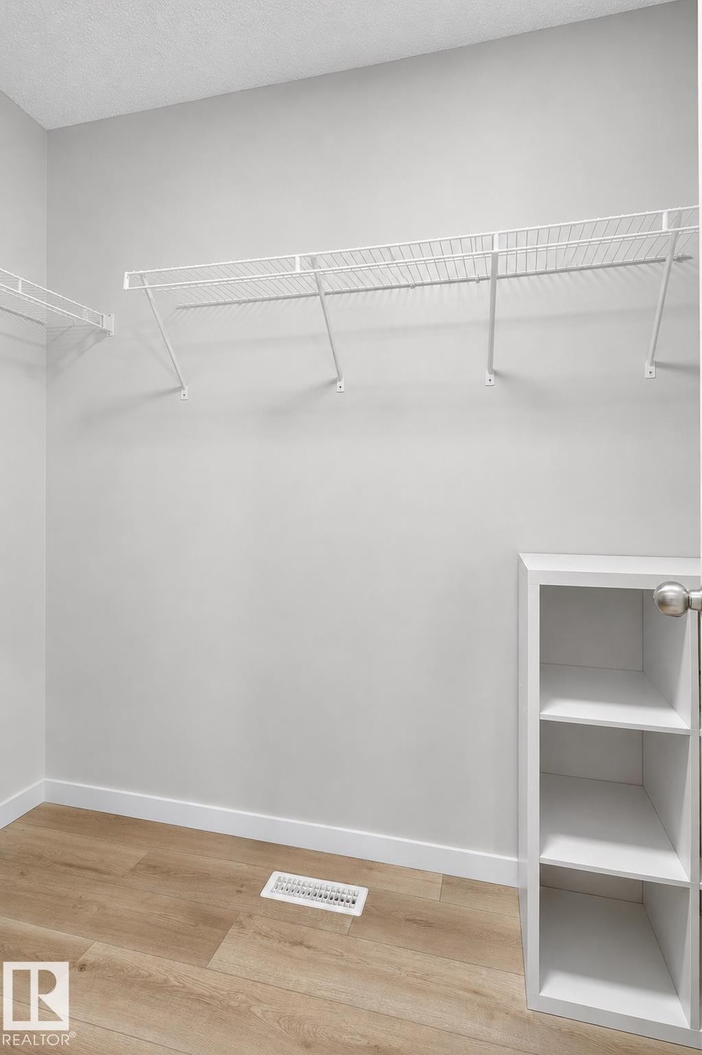 Closet space featuring wire shelving systems, built-in cubby storage, and wood-finish flooring - 22638 99A Avenue, Edmonton, AB