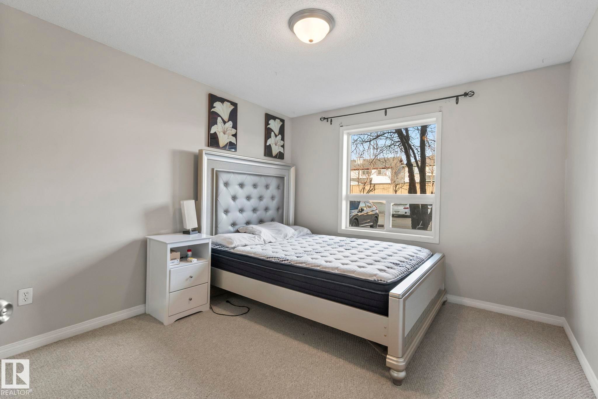 Bedroom featuring light gray wall paint, a single window with white trim, and a ceiling-mounted light fixture - 2106 9357 Simpson Dr Nw, Edmonton, AB - Indoor Photo Showing Bedroom