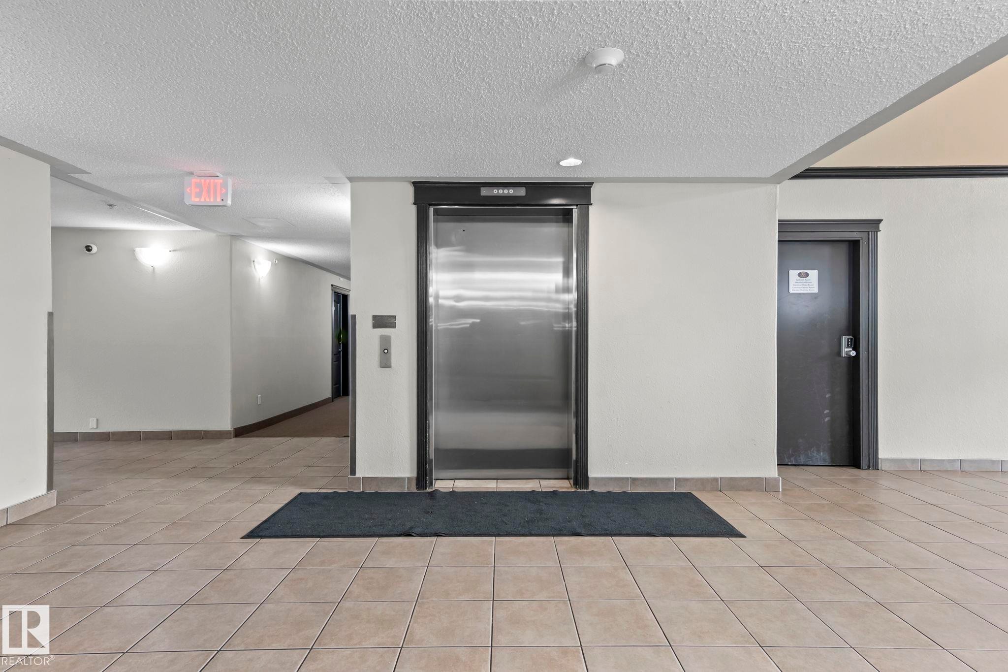 Central stainless steel elevator with dark trim - 2106 9357 Simpson Dr Nw, Edmonton, AB - Indoor Photo Showing Other Room