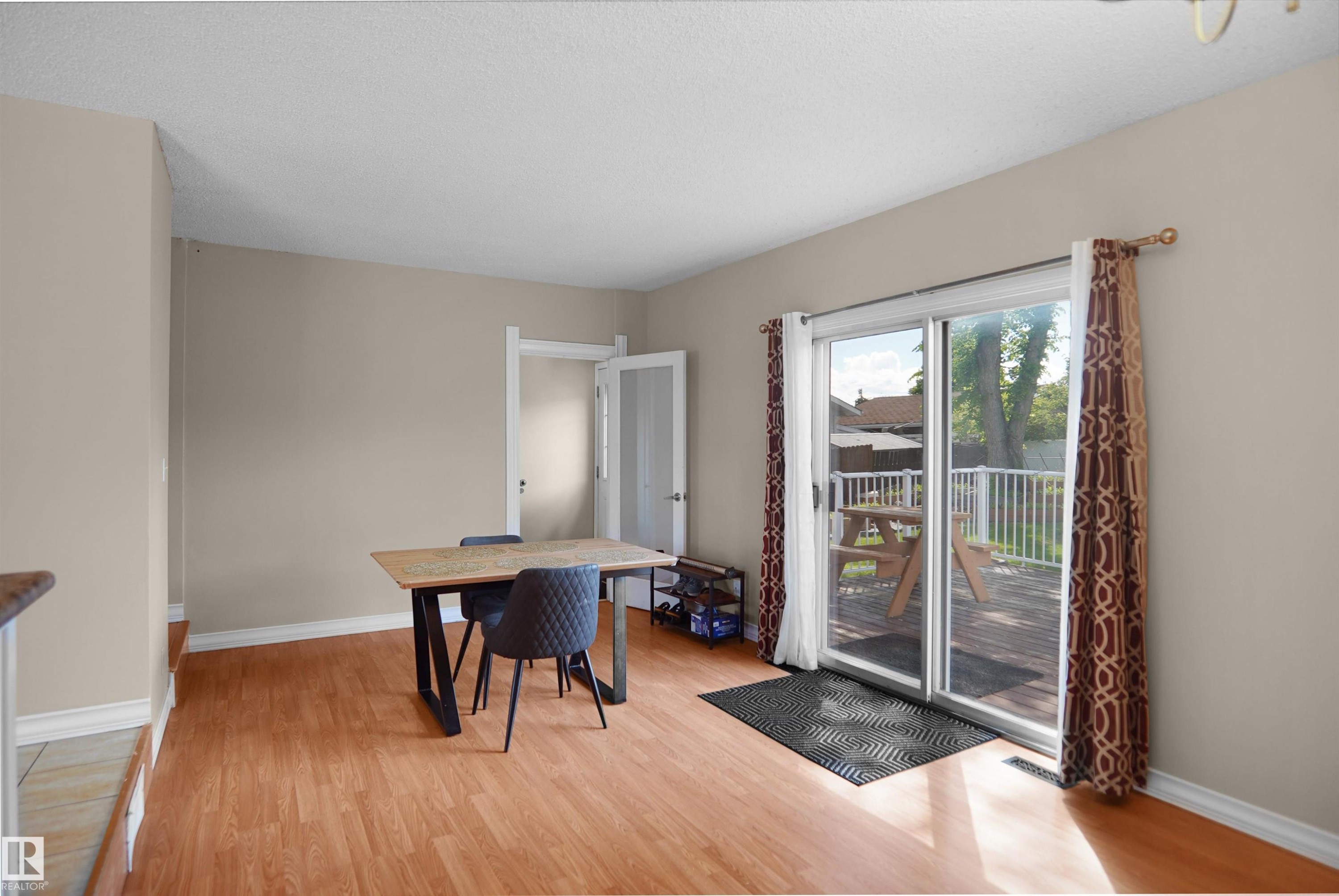 Wood-finish flooring throughout, featuring neutral wall paint and white trim - 13524 26 Street, Edmonton, AB