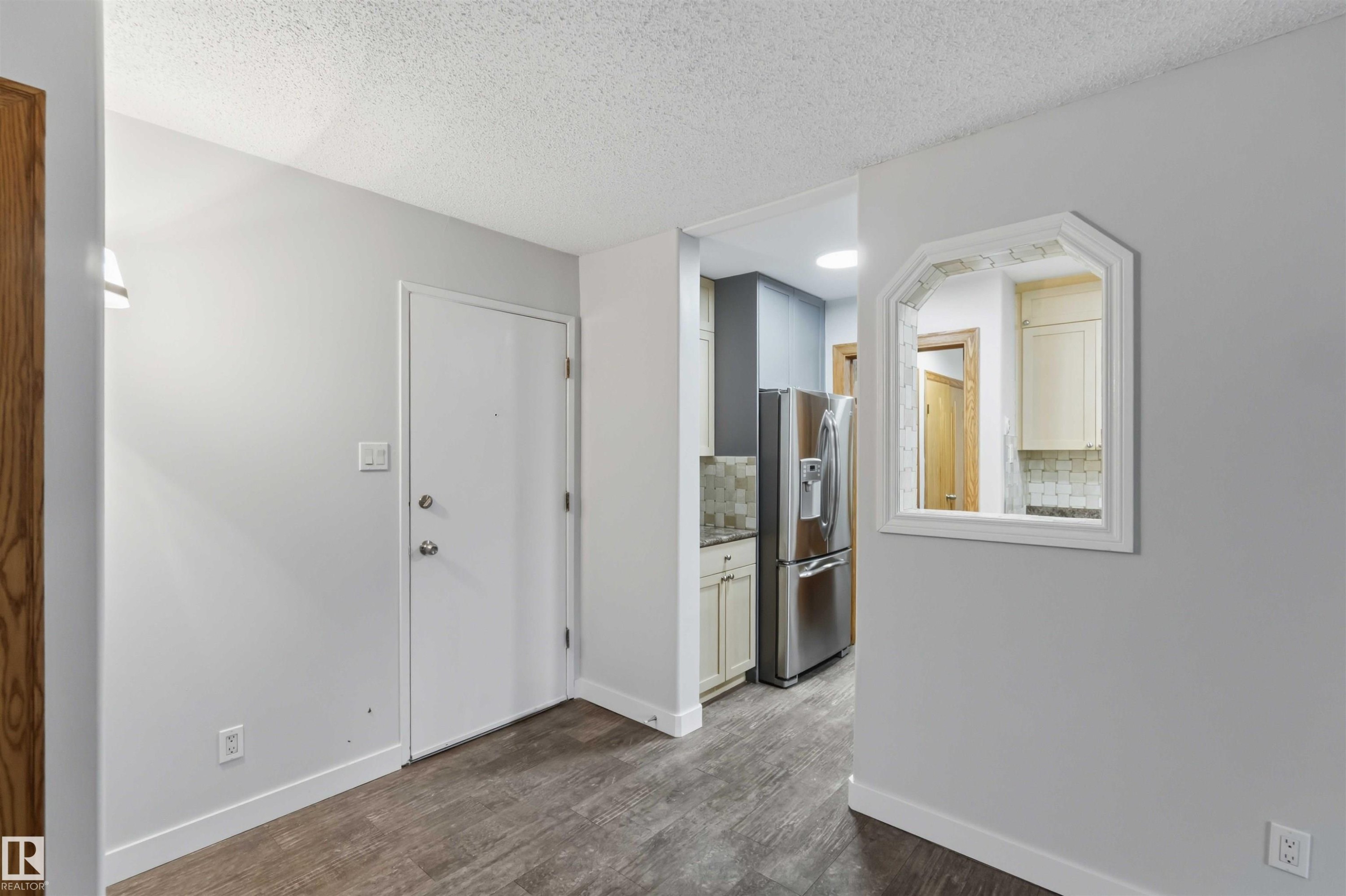 Interior featuring wood-finish flooring, light gray wall paint, and white baseboards - #121 5125 Riverbend Rd Nw Nw, Edmonton, AB - Indoor Photo Showing Other Room