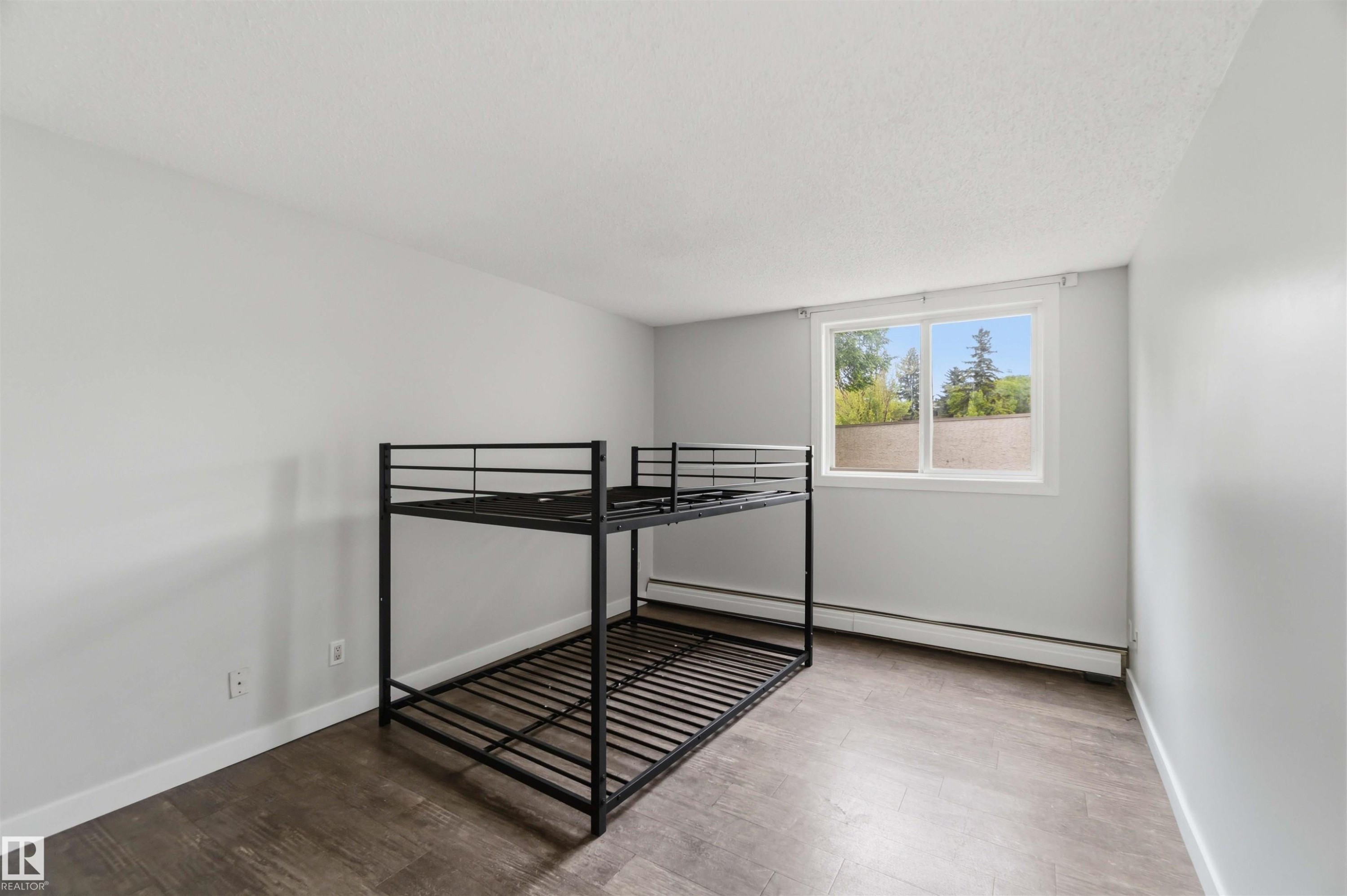 Room featuring light gray walls and wood-finish flooring - #121 5125 Riverbend Rd Nw Nw, Edmonton, AB - Indoor Photo Showing Other Room