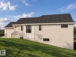 Exterior featuring horizontal siding, a dark shingle roof, black-framed windows, and stone accents - 